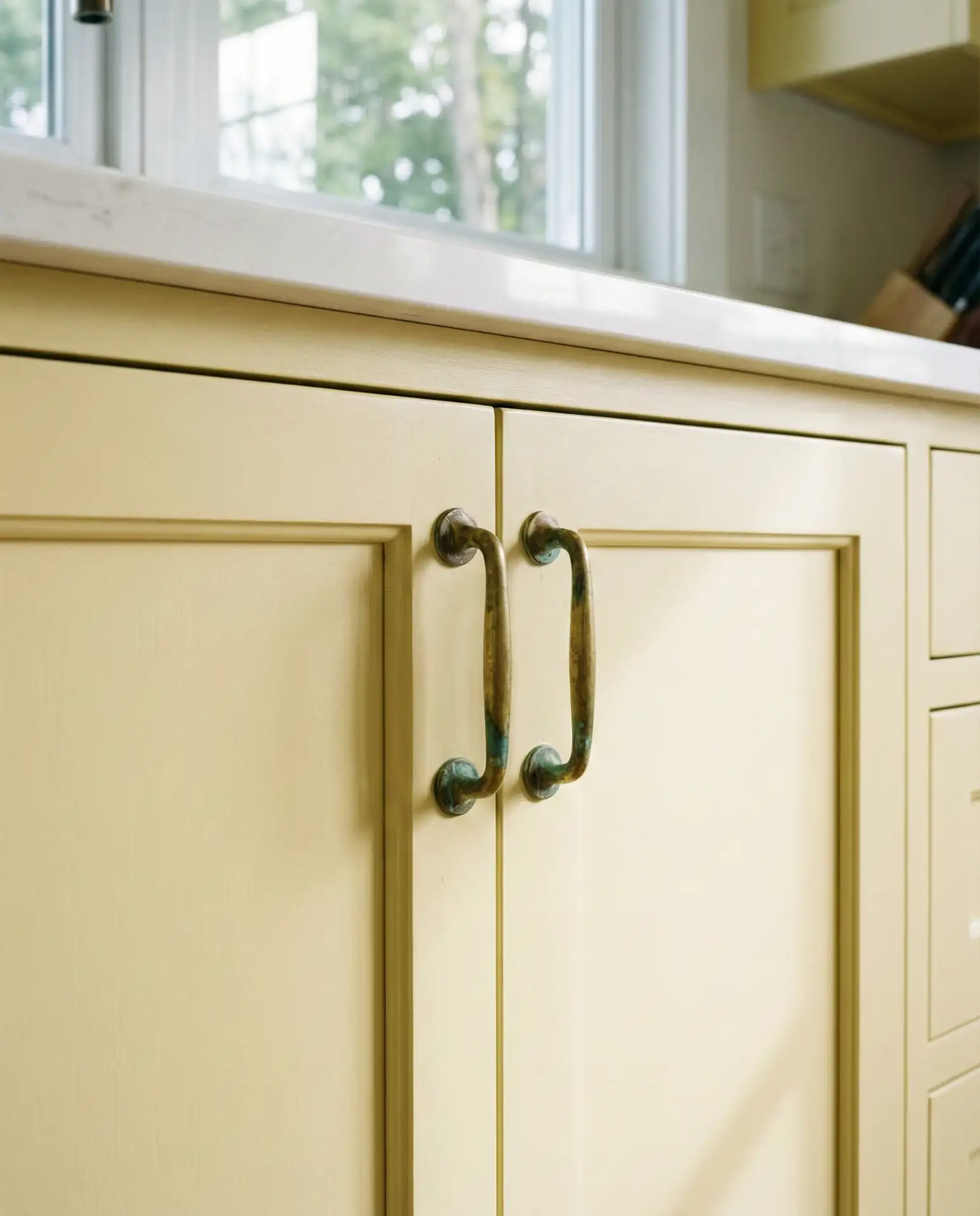 Pale Yellow Shaker Cabinets with Brass Hardware 2