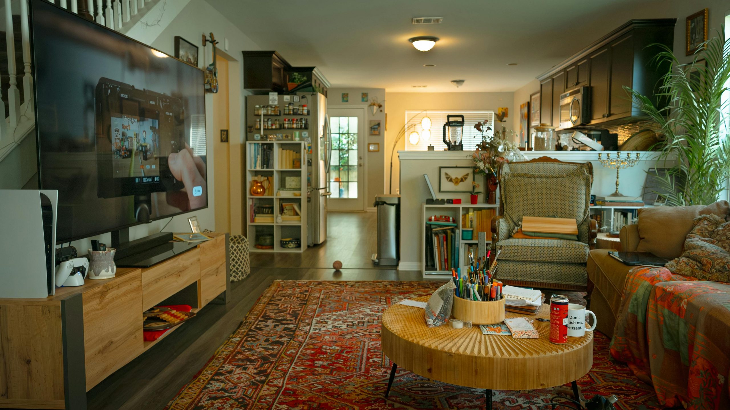 A bright and cozy living room featuring eclectic decor, bookshelf, and entertainment center.