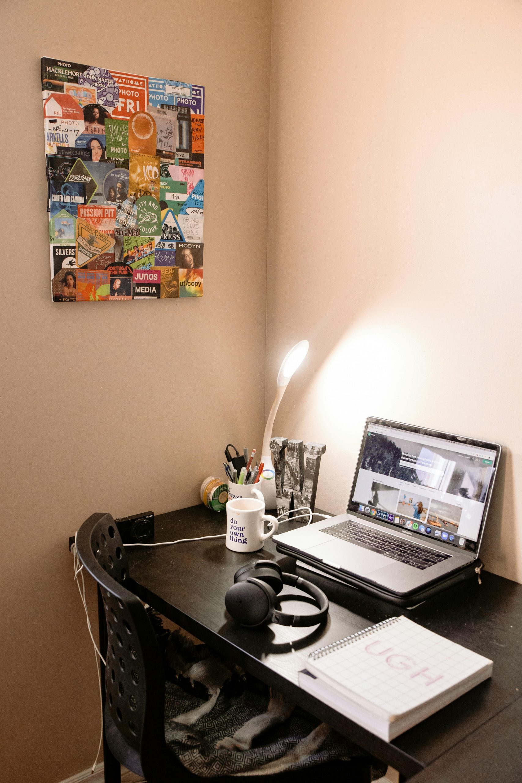 A bright, clutter-free home office corner featuring a laptop, headphones, and motivational wall decor.