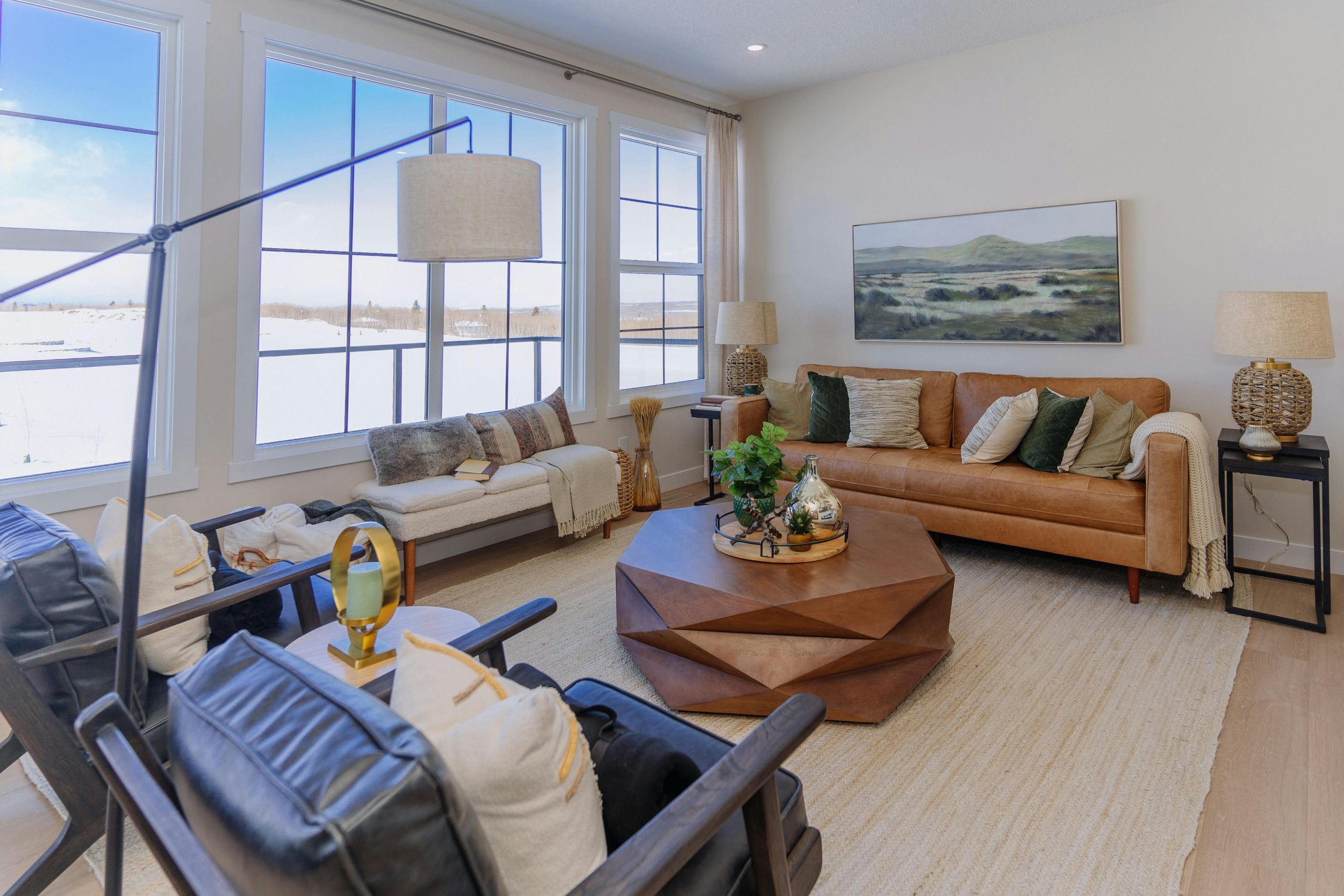 A bright, elegant living room features large windows and stylish decor elements.