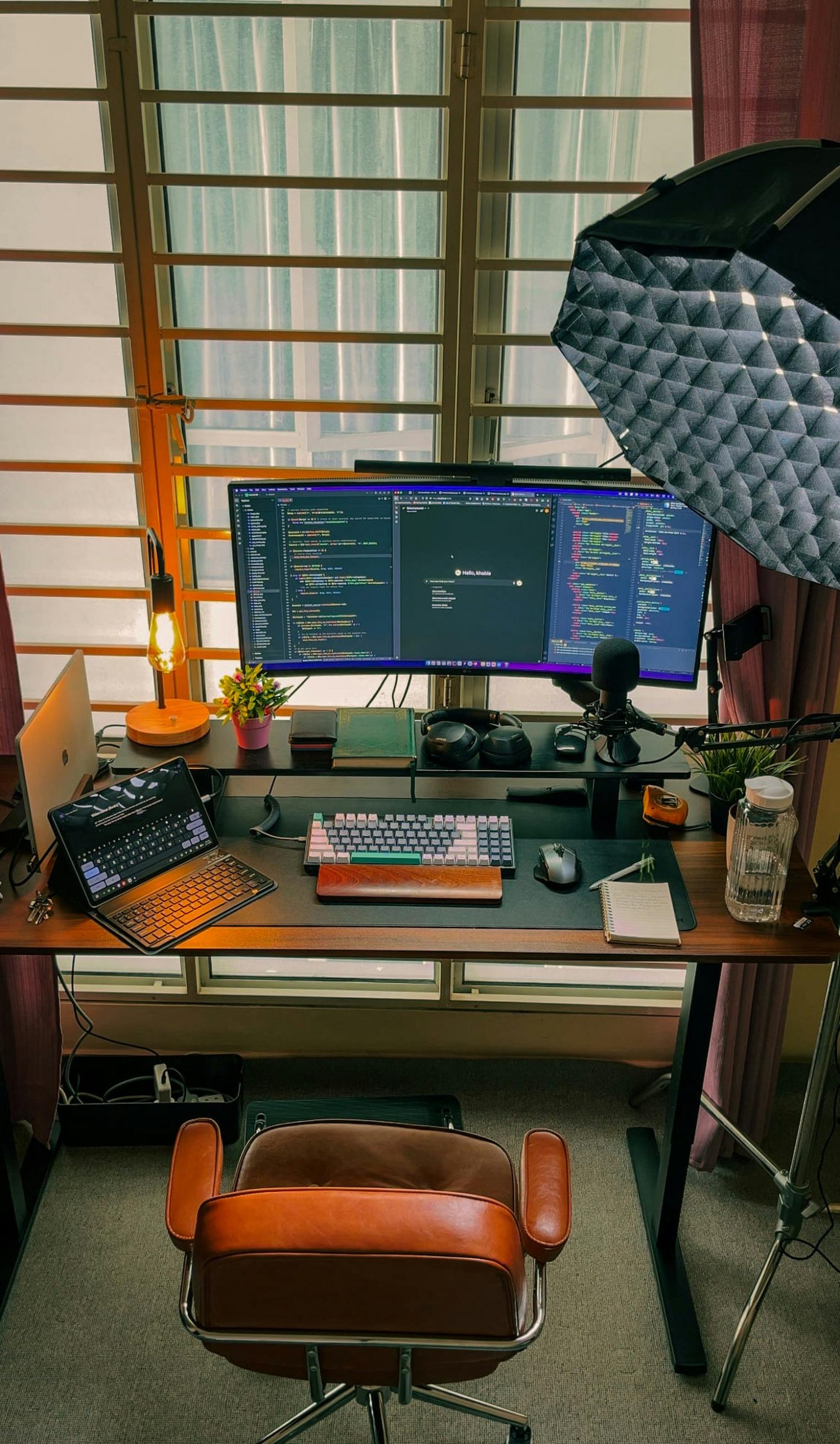 A cozy home office setup featuring dual monitors, perfect for programming and tech enthusiasts.