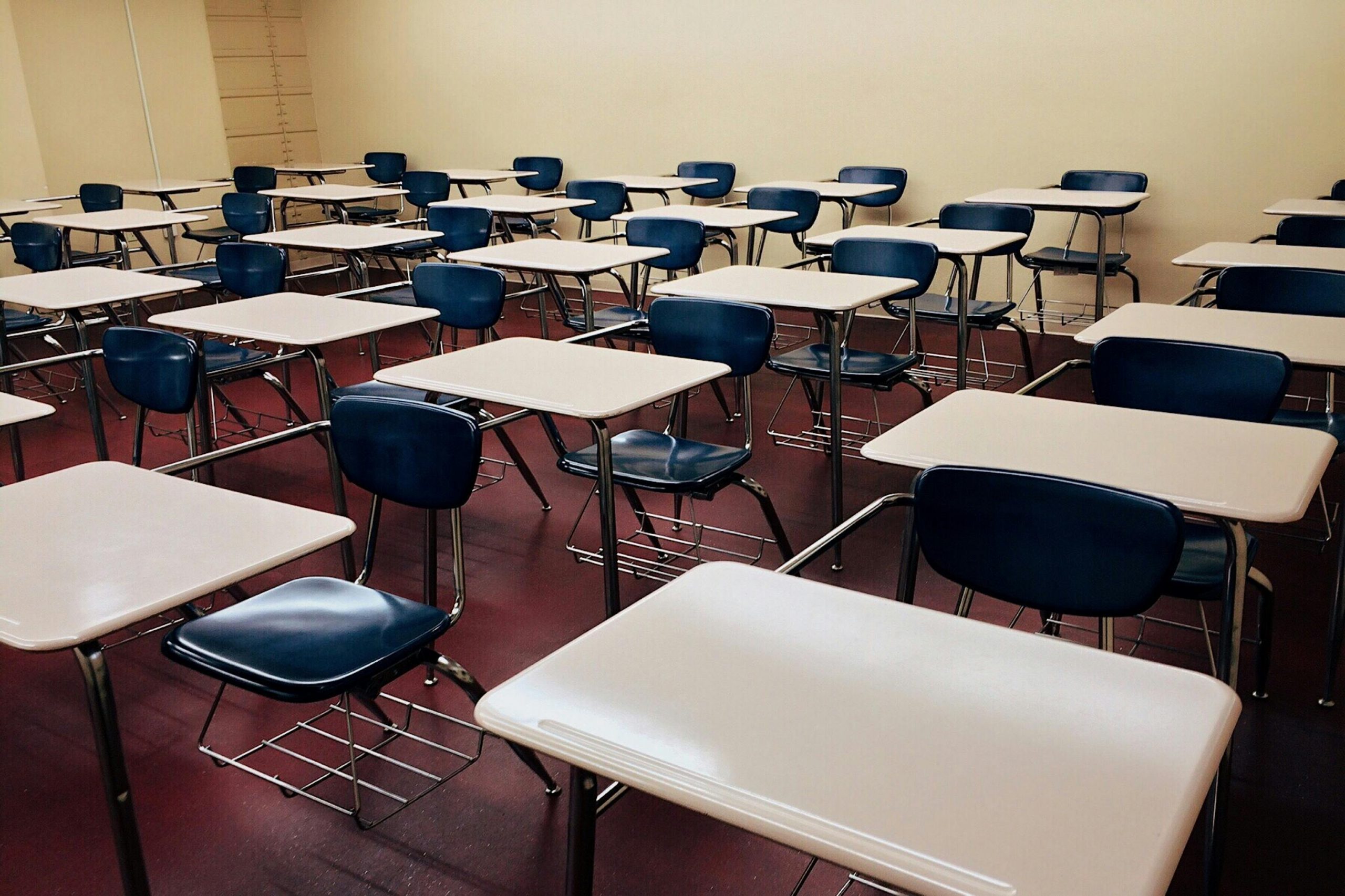 An empty classroom featuring neatly arranged desks and chairs ready for use.