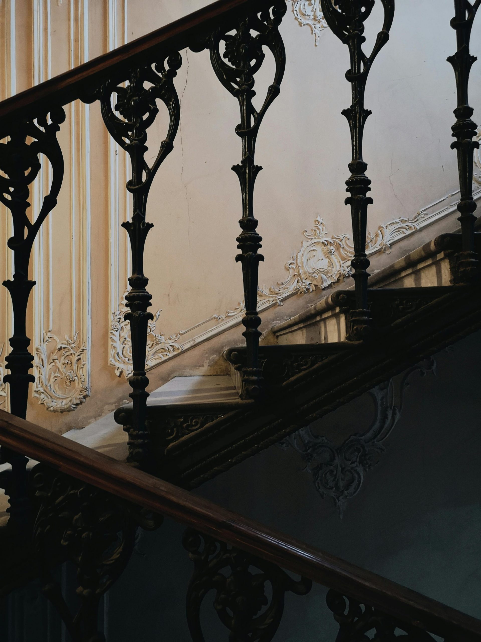 Beautifully crafted staircase featuring ornate iron railings and wooden steps in a classic interior design.
