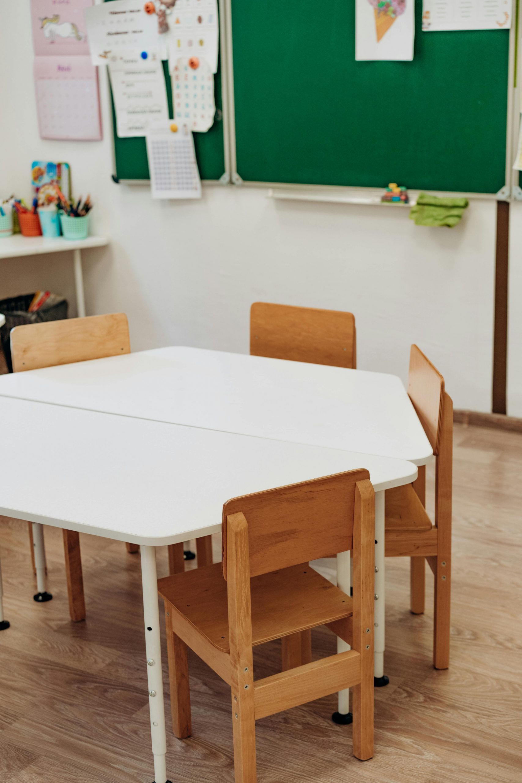 Cozy kindergarten classroom featuring wooden chairs and a white table, ideal for a learning environment.