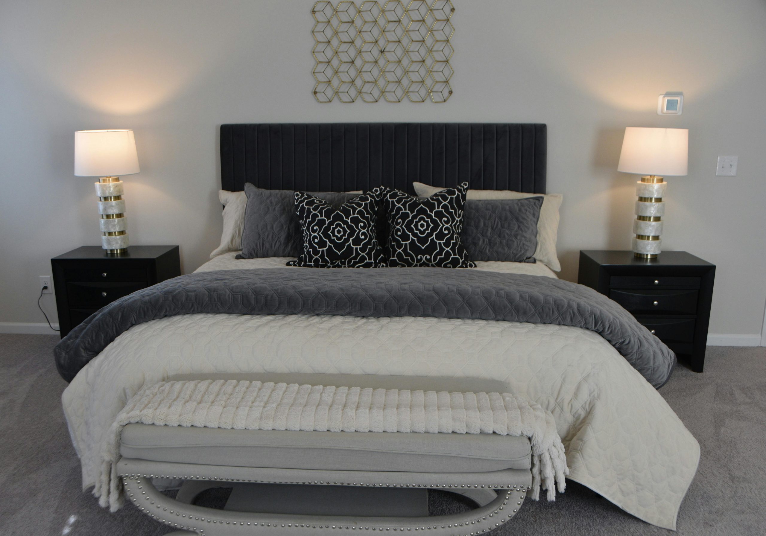 Elegant and cozy modern bedroom featuring chic decor, lamps, and a comfortable bed setup.