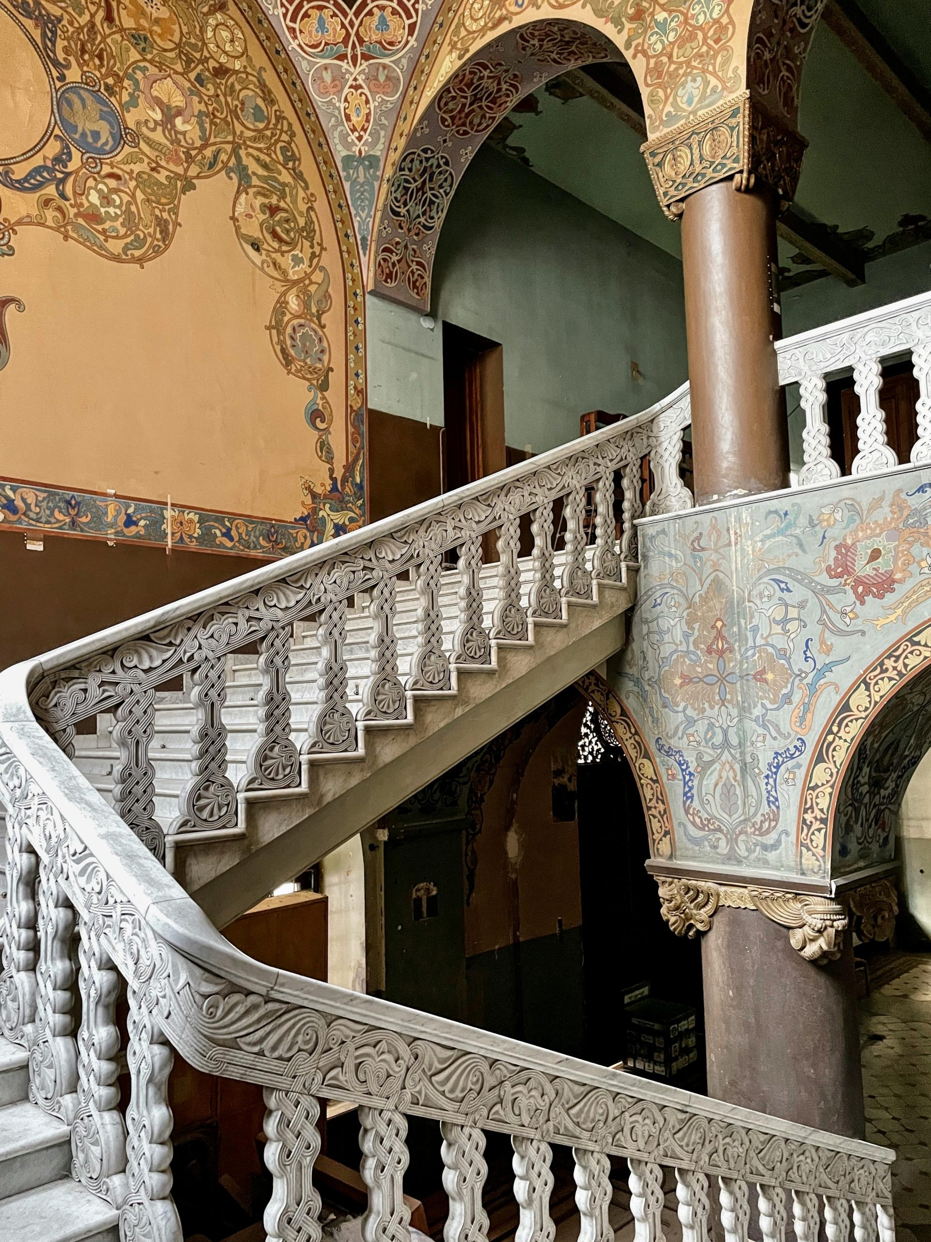 Elegant staircase with intricate designs in historic Tbilisi building.