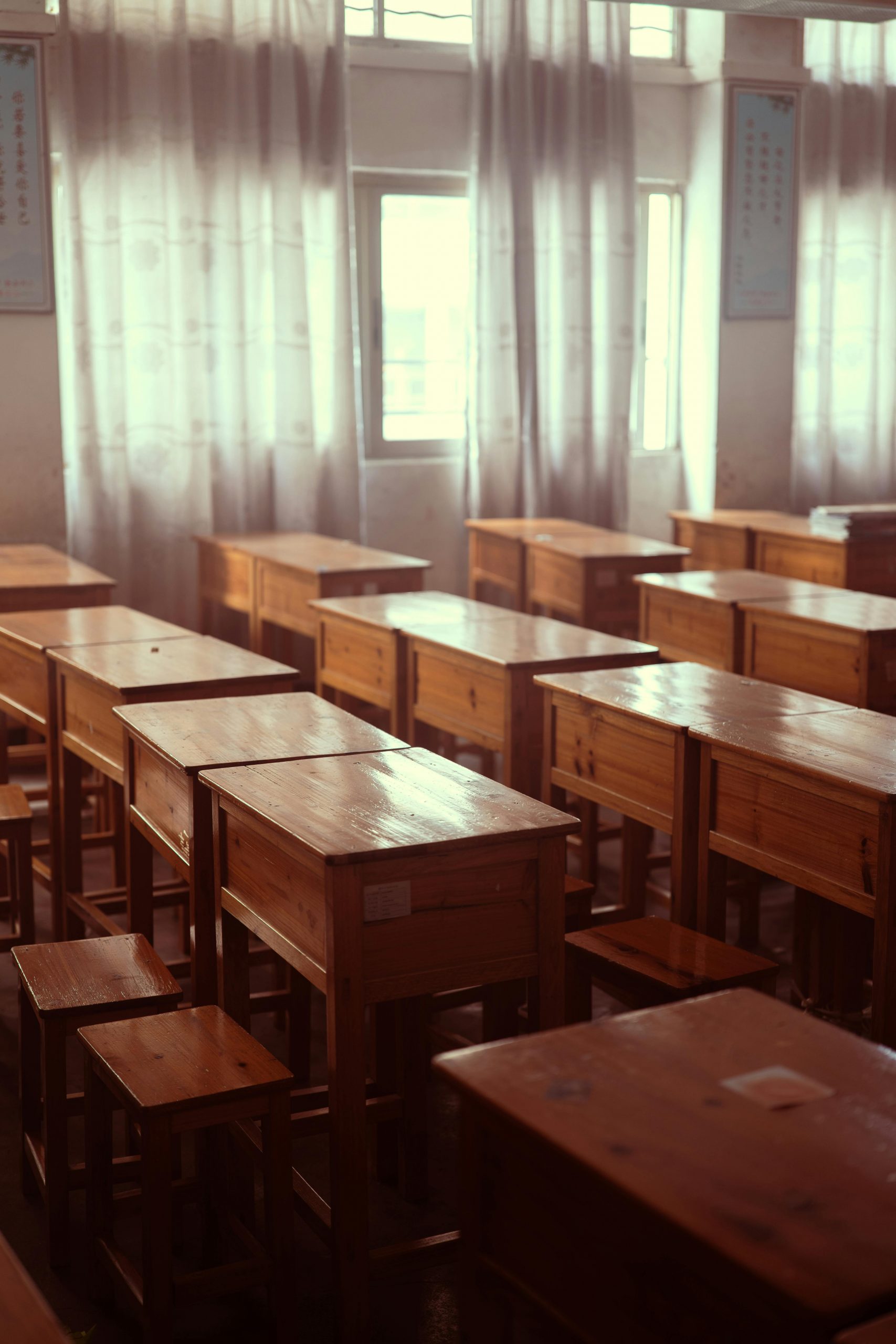 Serene empty classroom filled with wooden desks and soft lighting creating a peaceful atmosphere.