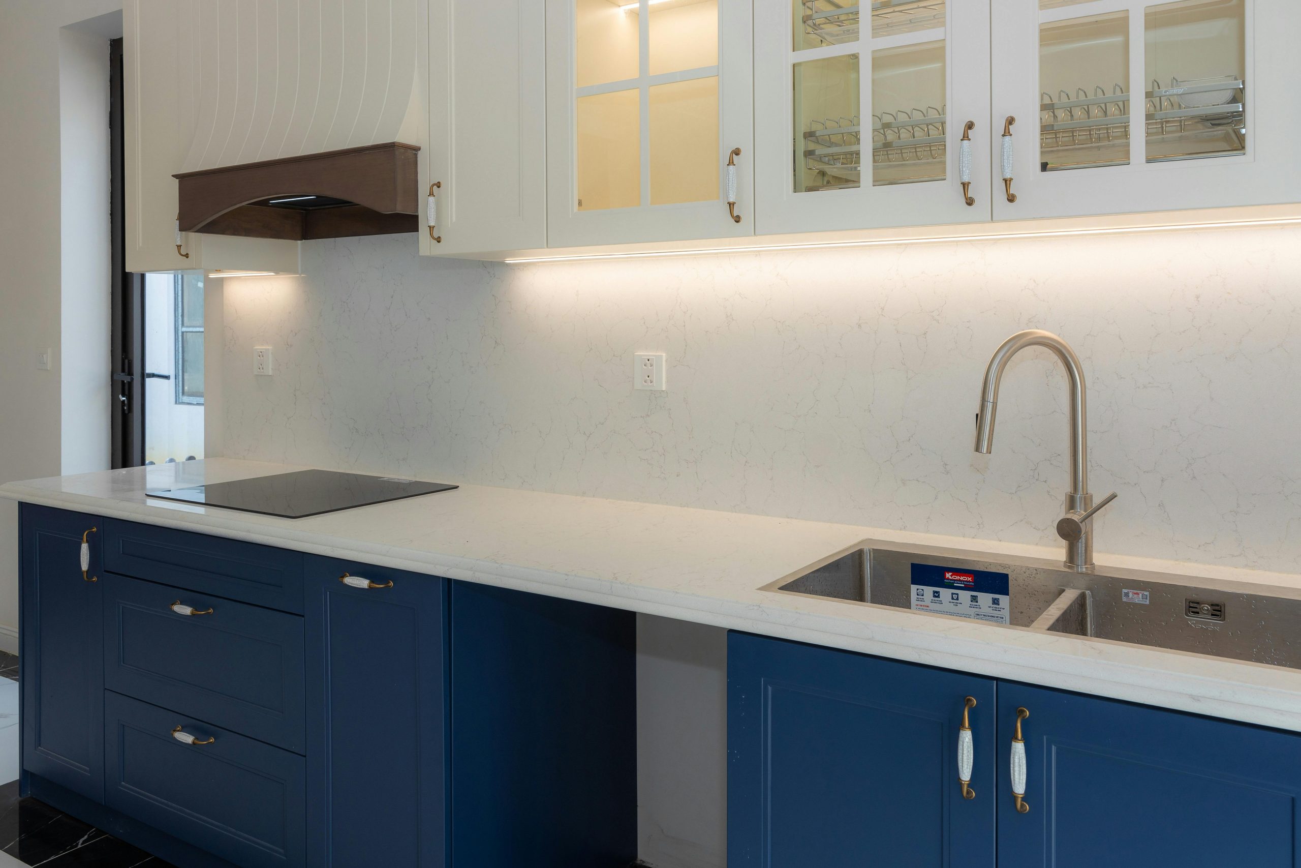 Sleek kitchen featuring blue cabinets, white countertops, and modern fixtures.