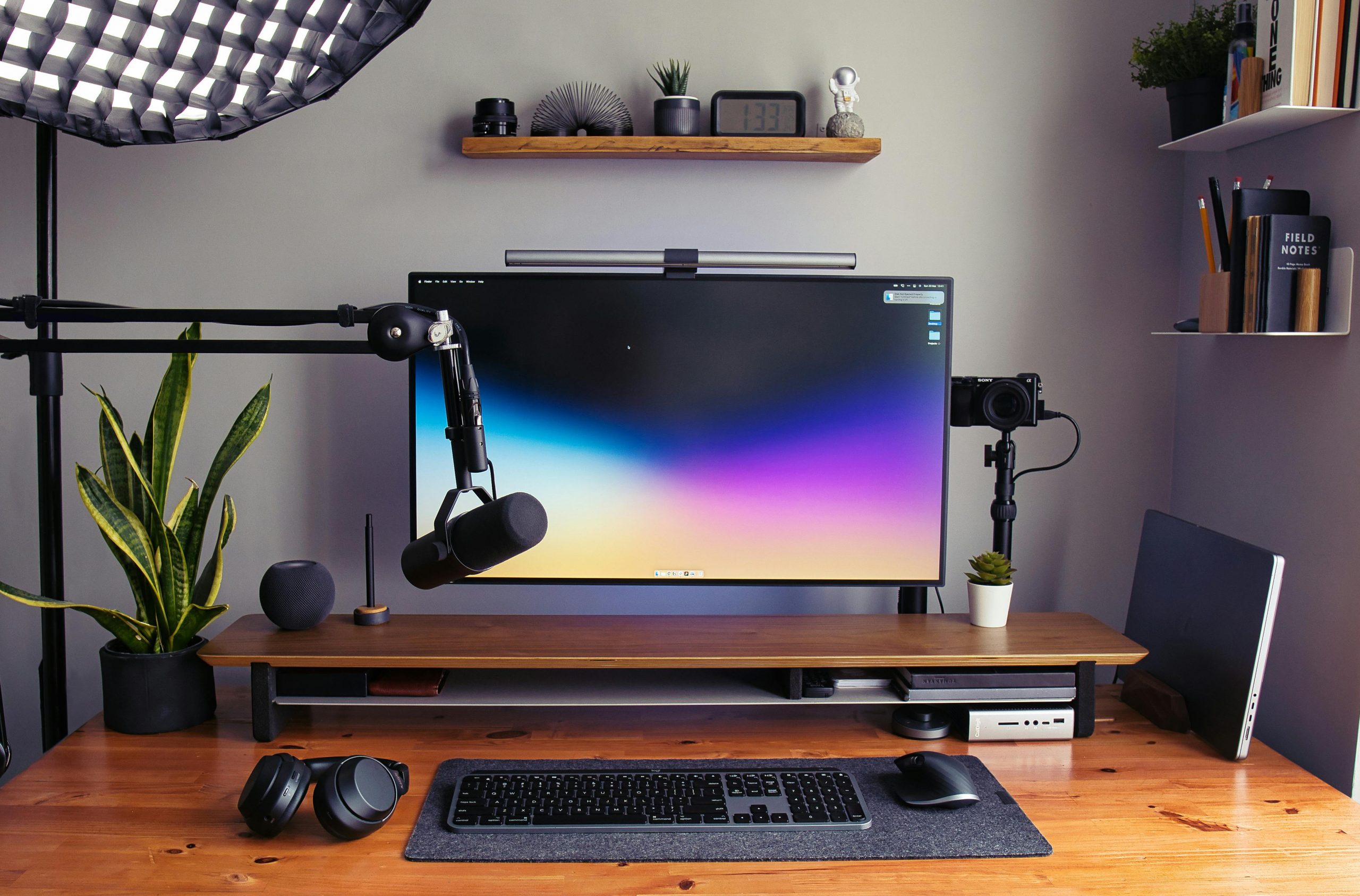 Sleek modern home office setup featuring a computer monitor, microphone, and desk accessories.