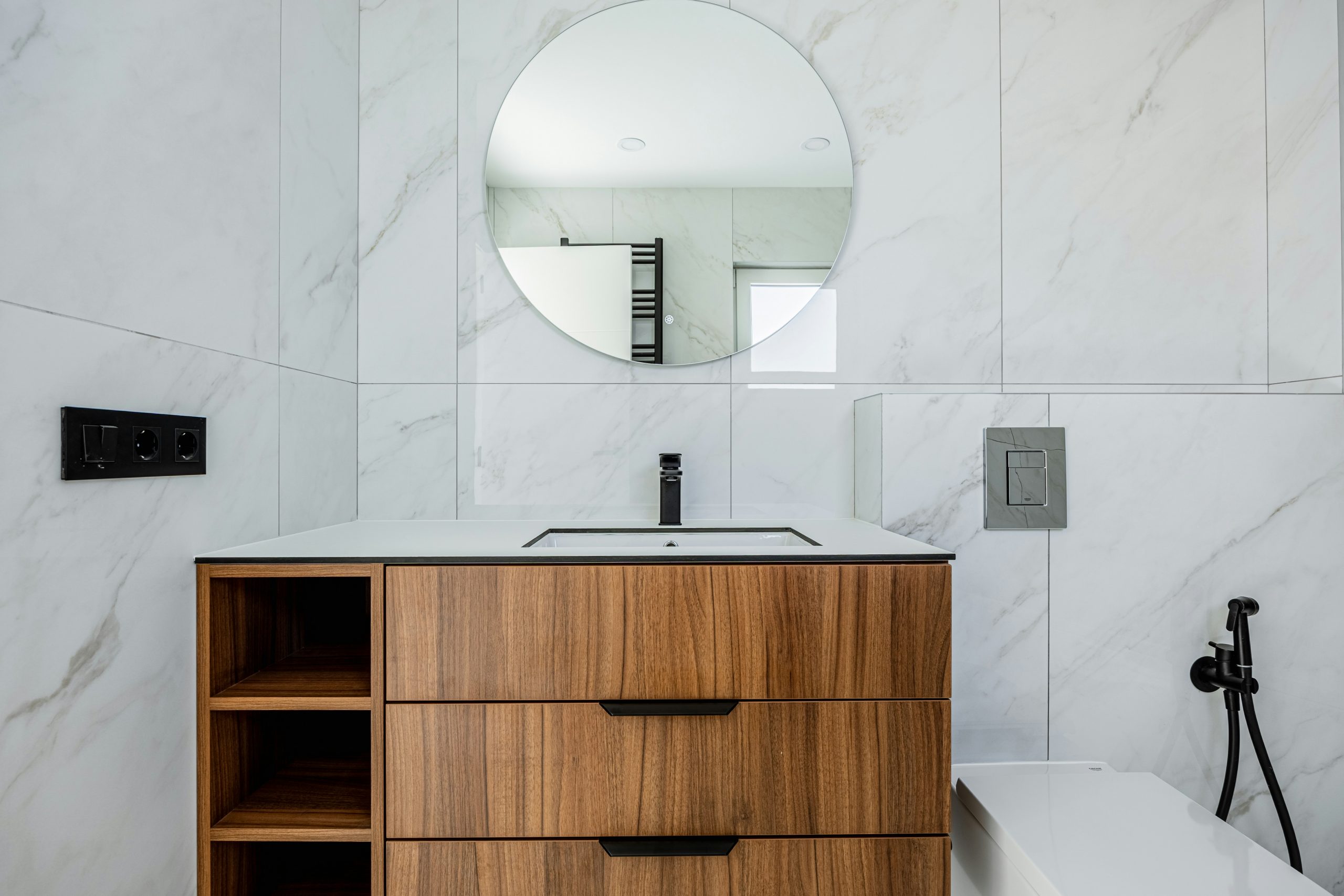 Stylish bathroom with wooden vanity and marble wall