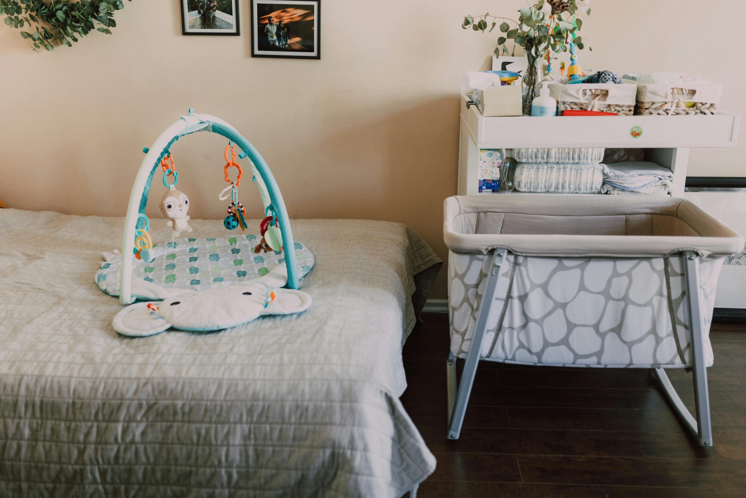 Stylish nursery with playmat, bassinet, and changing table for a cozy baby room.