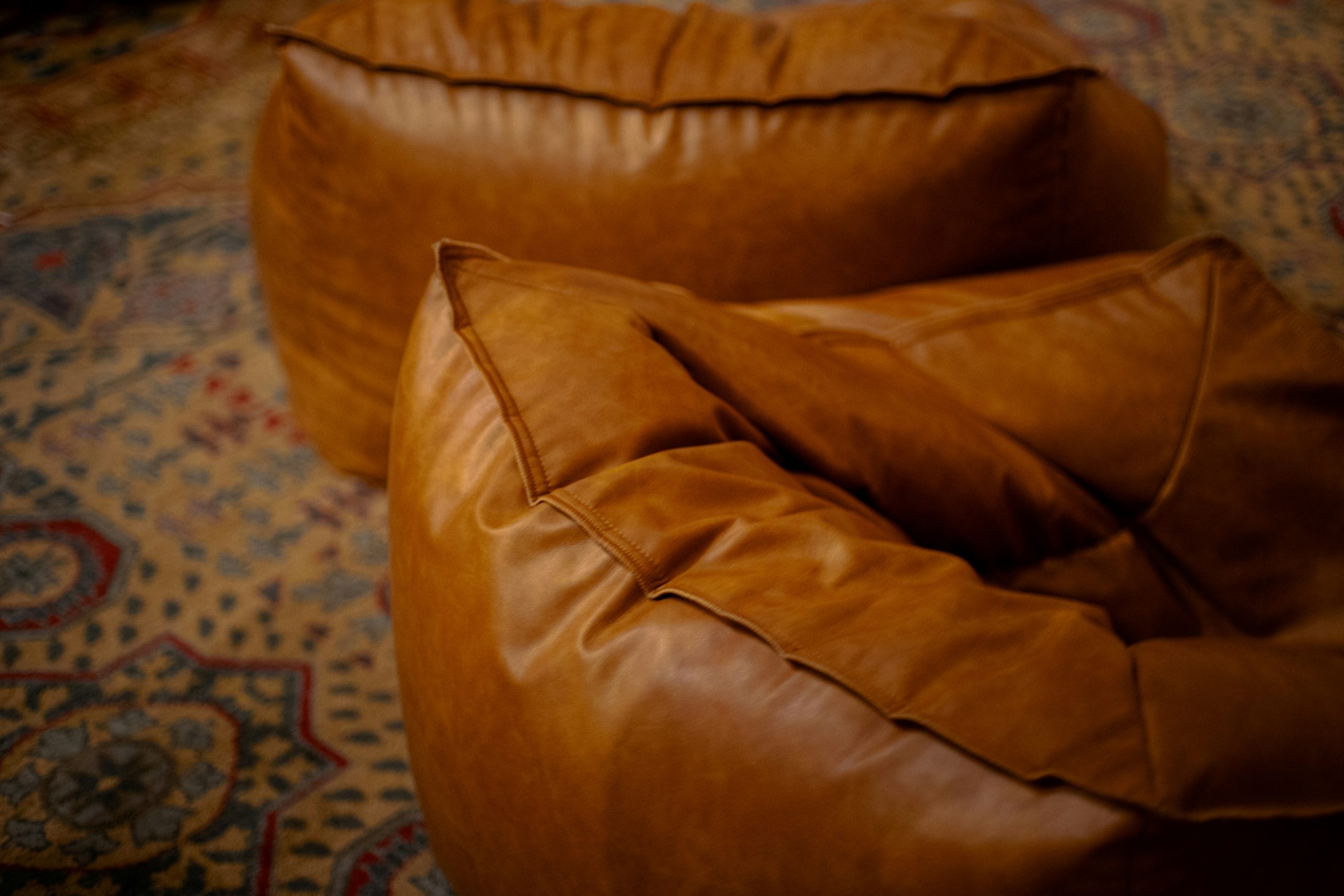 Two brown leather beanbag chairs.