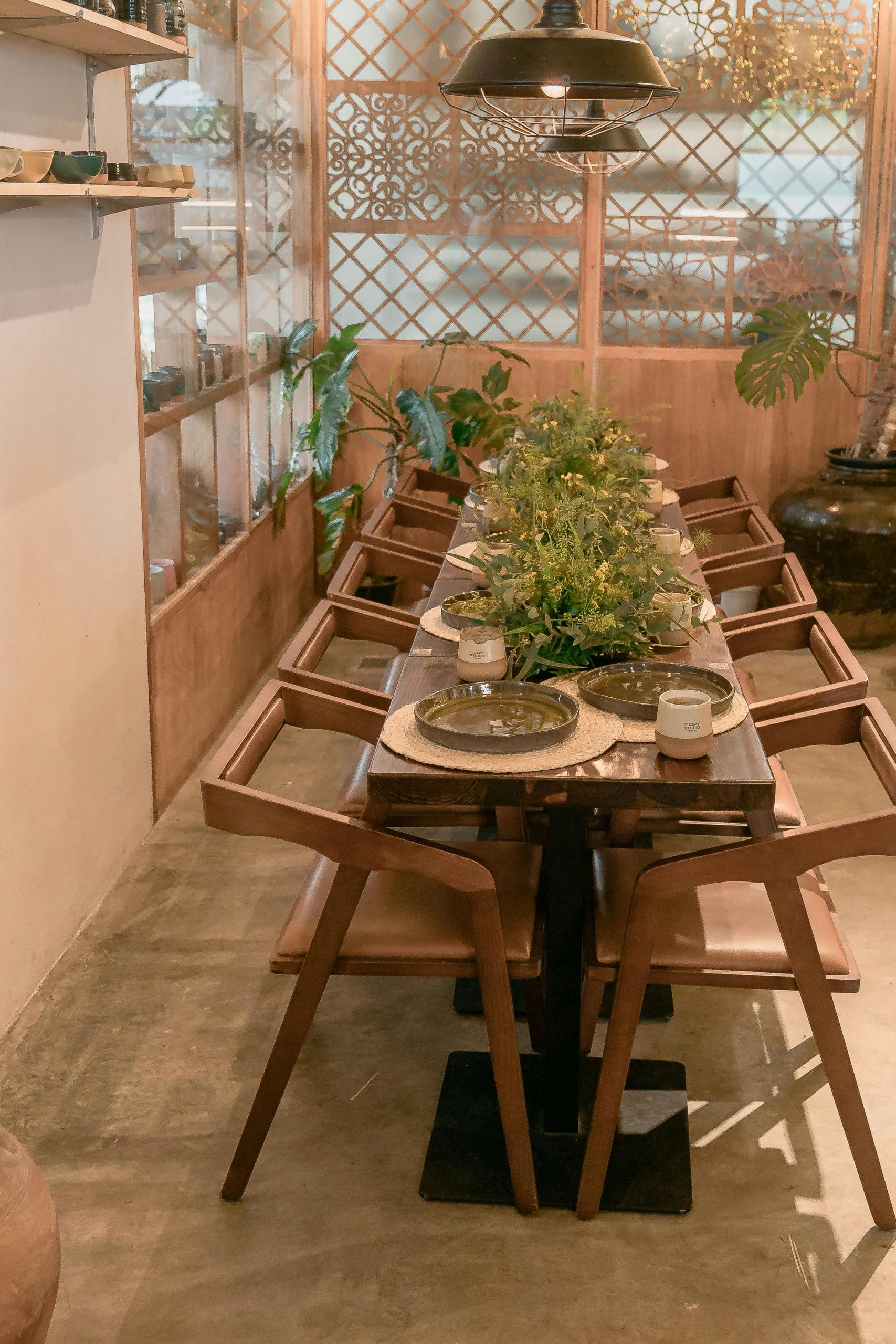 A beautifully arranged dining table with wooden chairs and elegant decor in a cozy indoor environment.