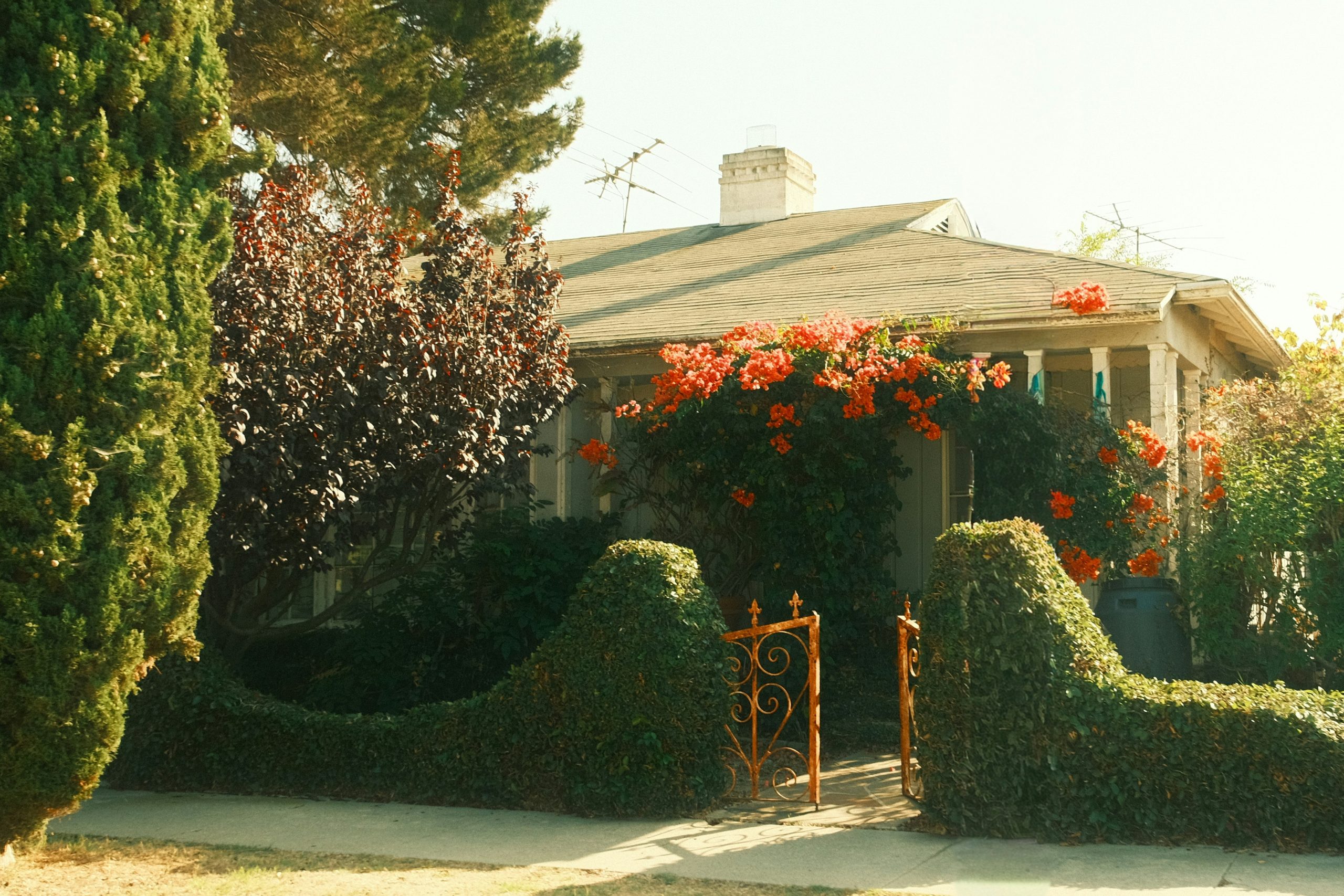 A charming house with blooming red flowers and orange flowers.