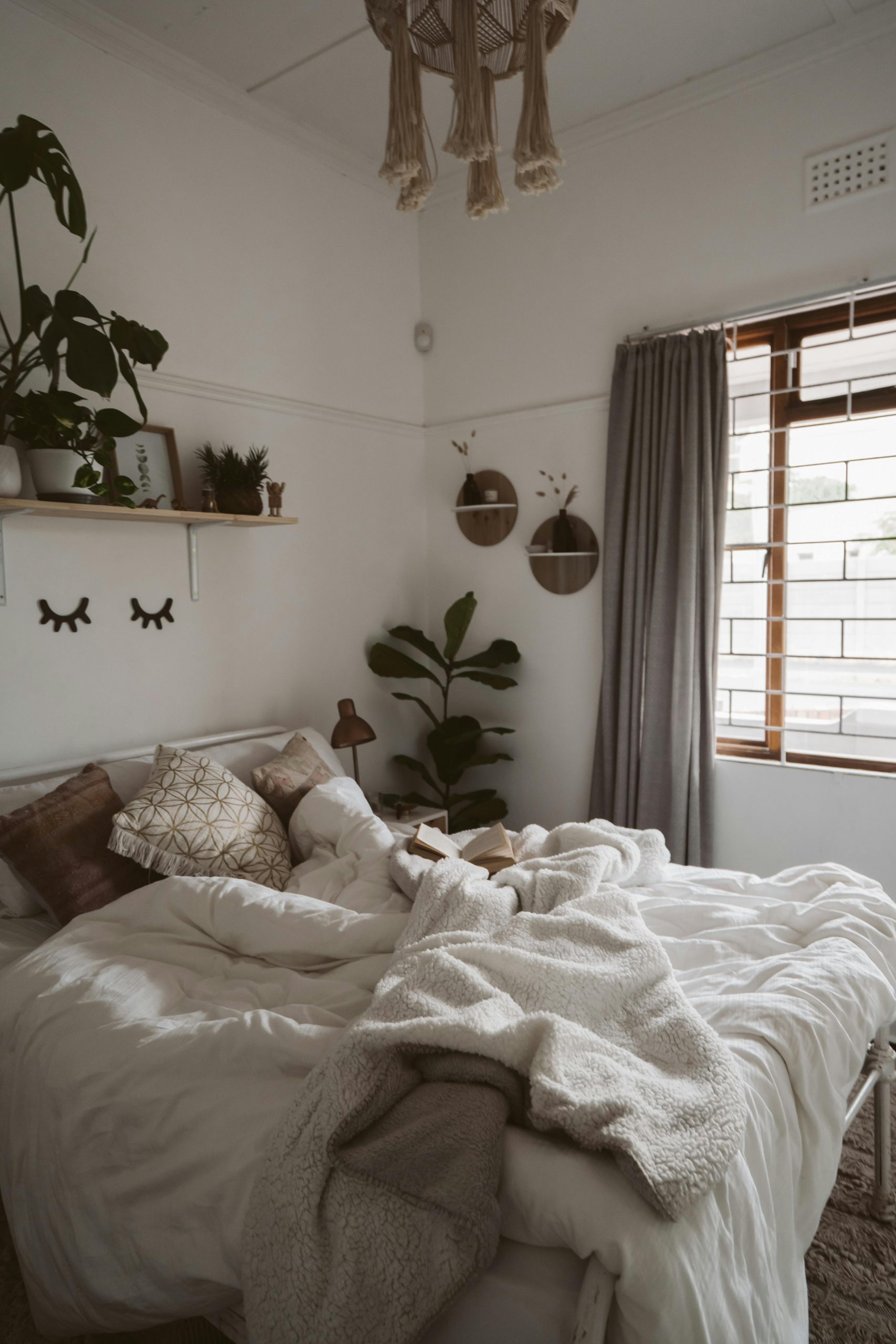 A cozy bedroom with stylish decor, plants, and soft linens for ultimate comfort.