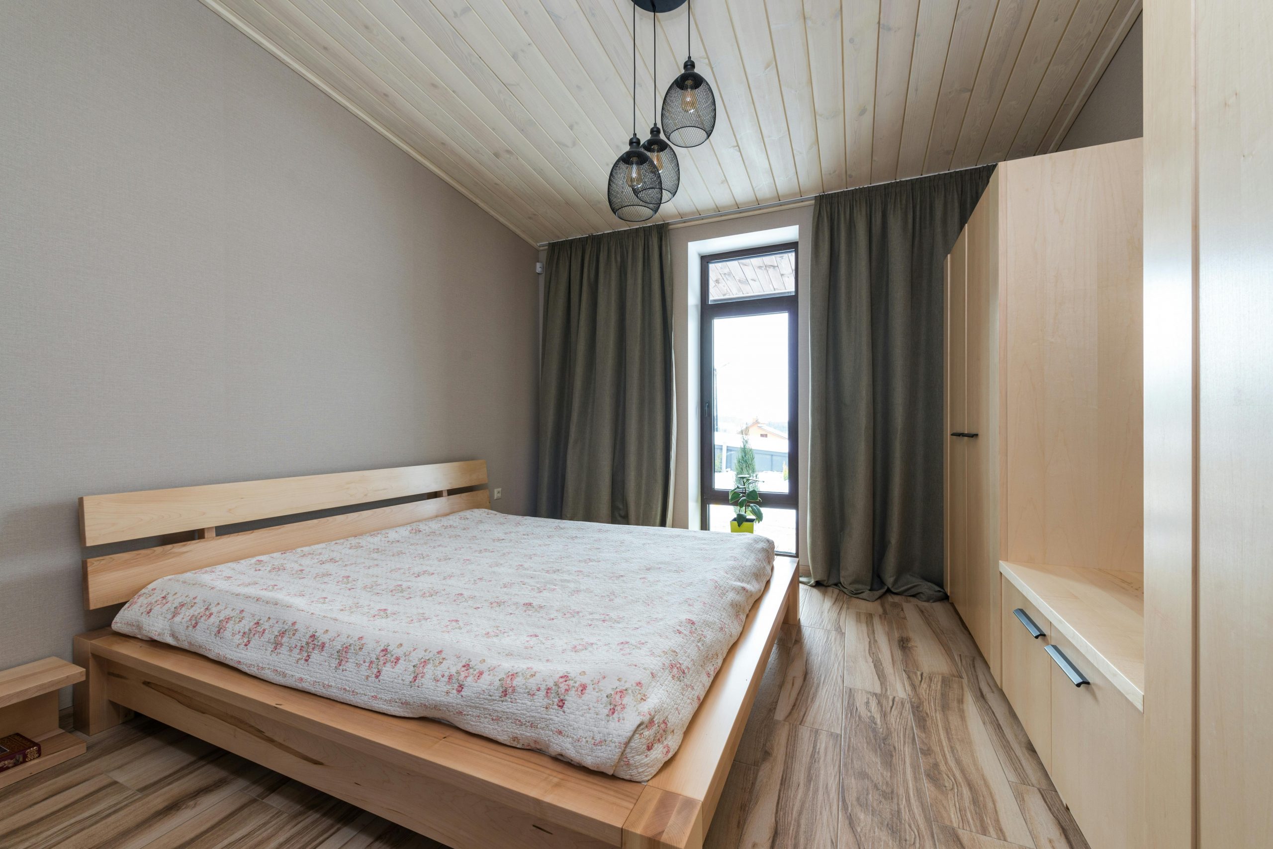 A cozy modern bedroom with wooden furniture and natural light.