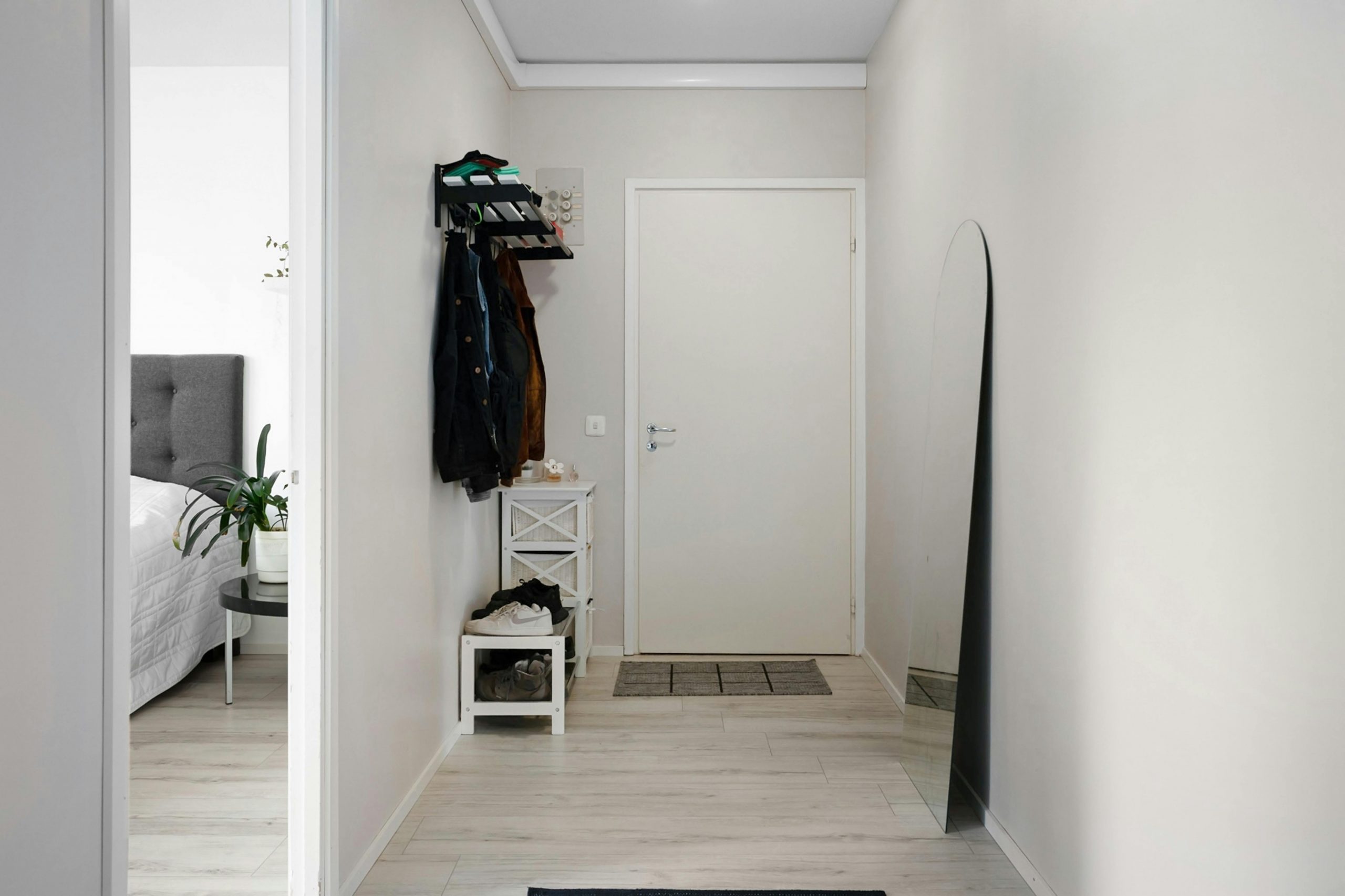 A minimalist hallway with white walls, modern decor, and simple furnishings.