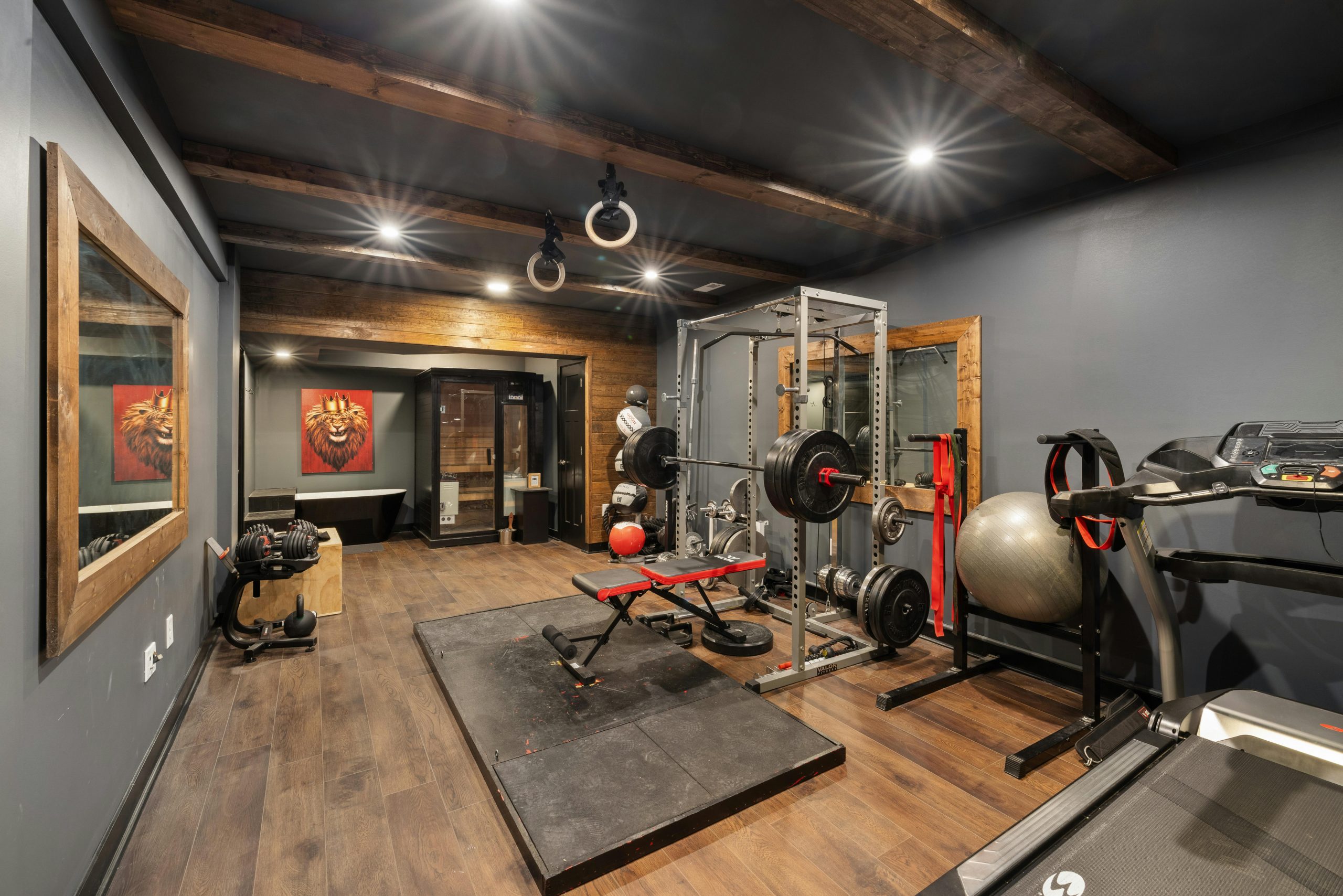 A modern home gym setup with weights, treadmill, and fitness equipment.
