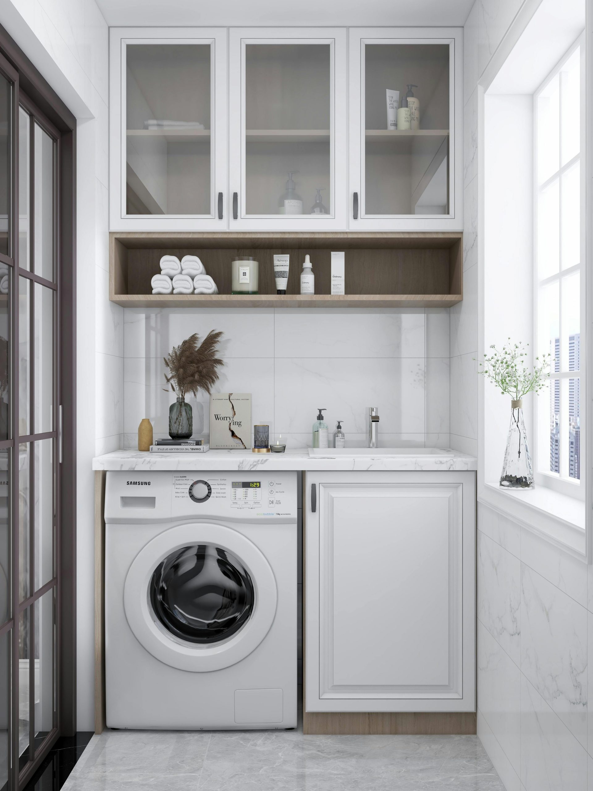 A sleek and bright laundry room featuring a washing machine, cabinets, and natural decor.