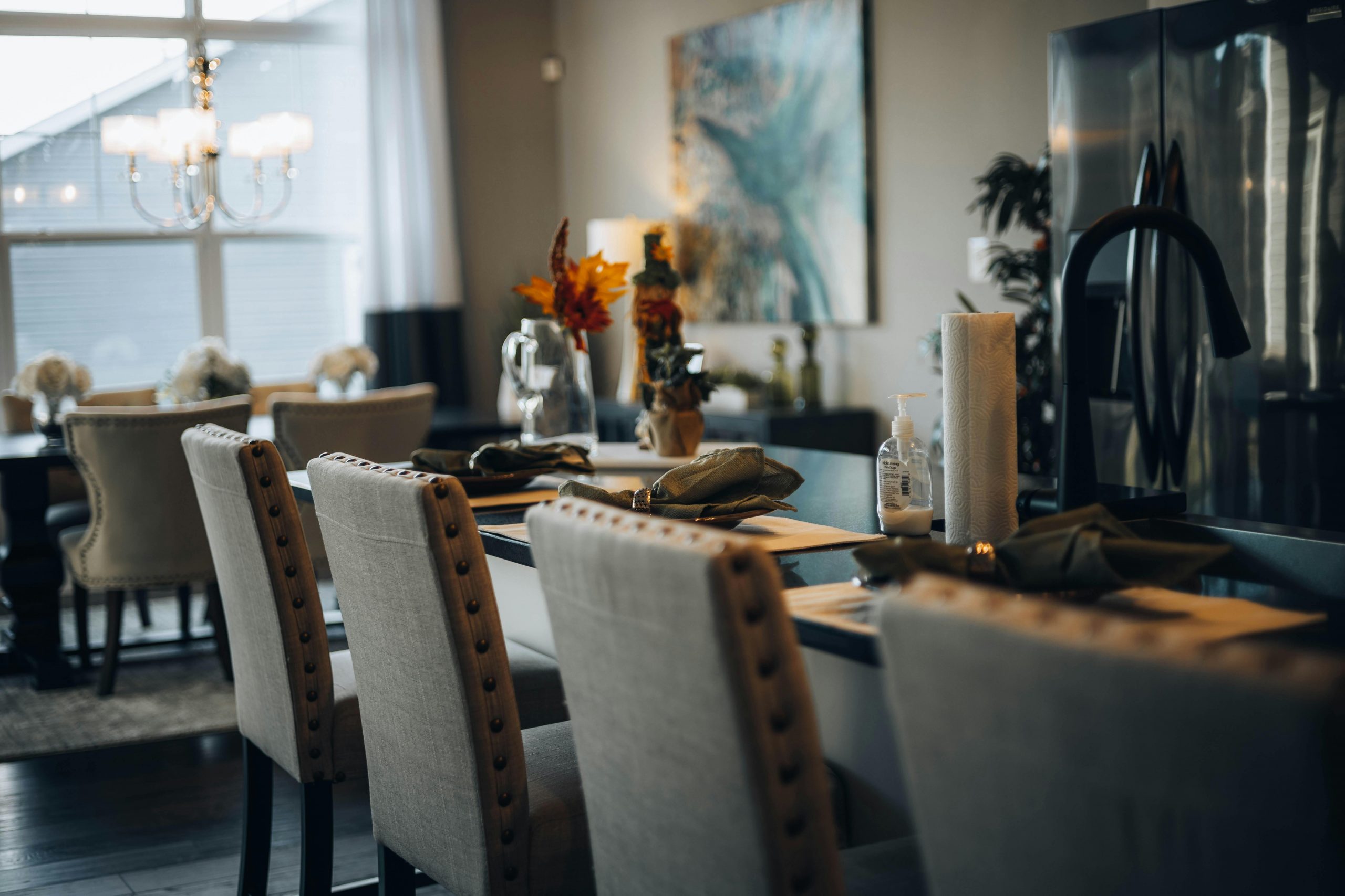A sophisticated dining room setup with a modern table, elegant chairs, and ambient lighting.