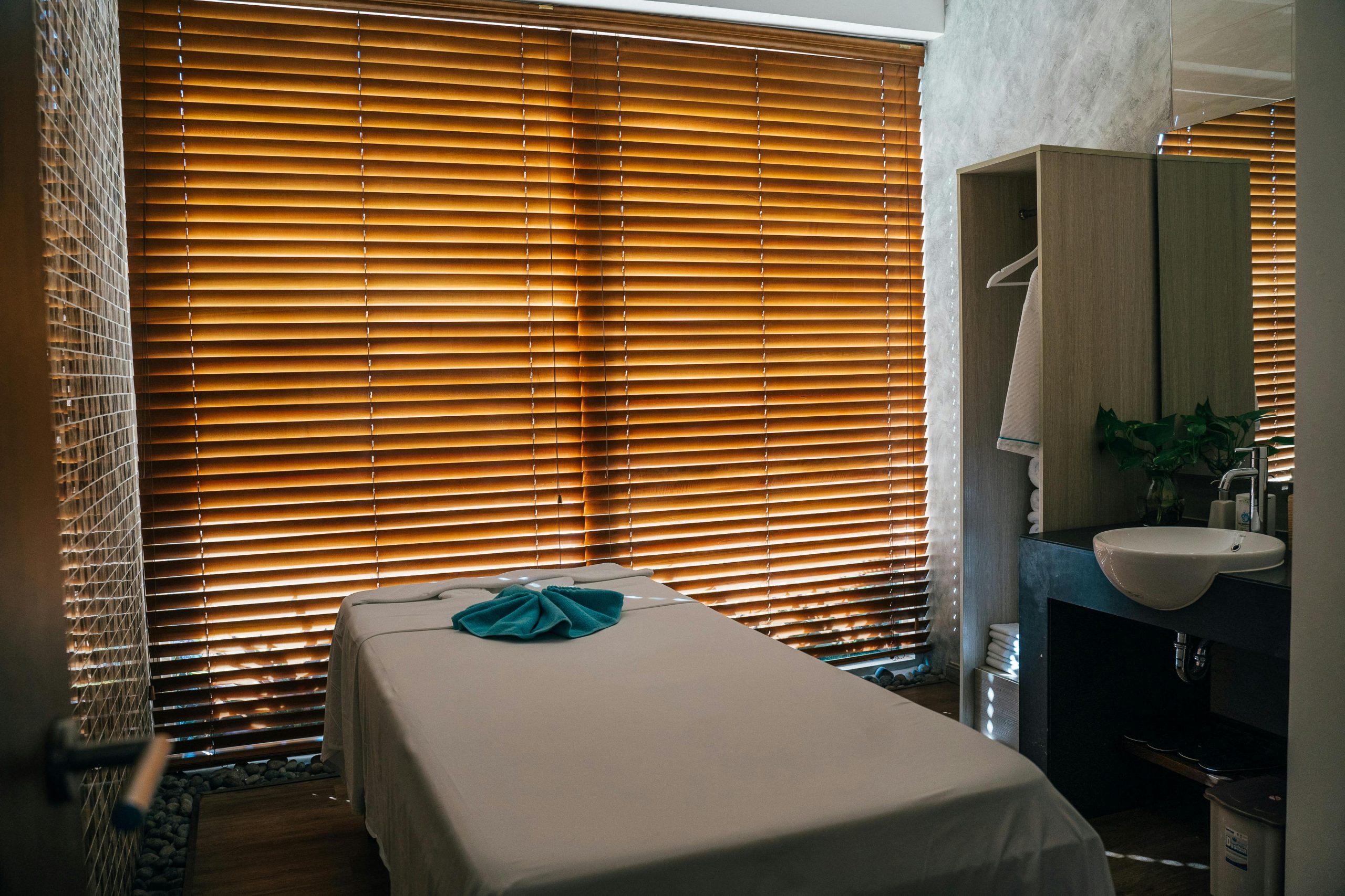 A tranquil massage room with natural light and neatly arranged furnishings for relaxation.