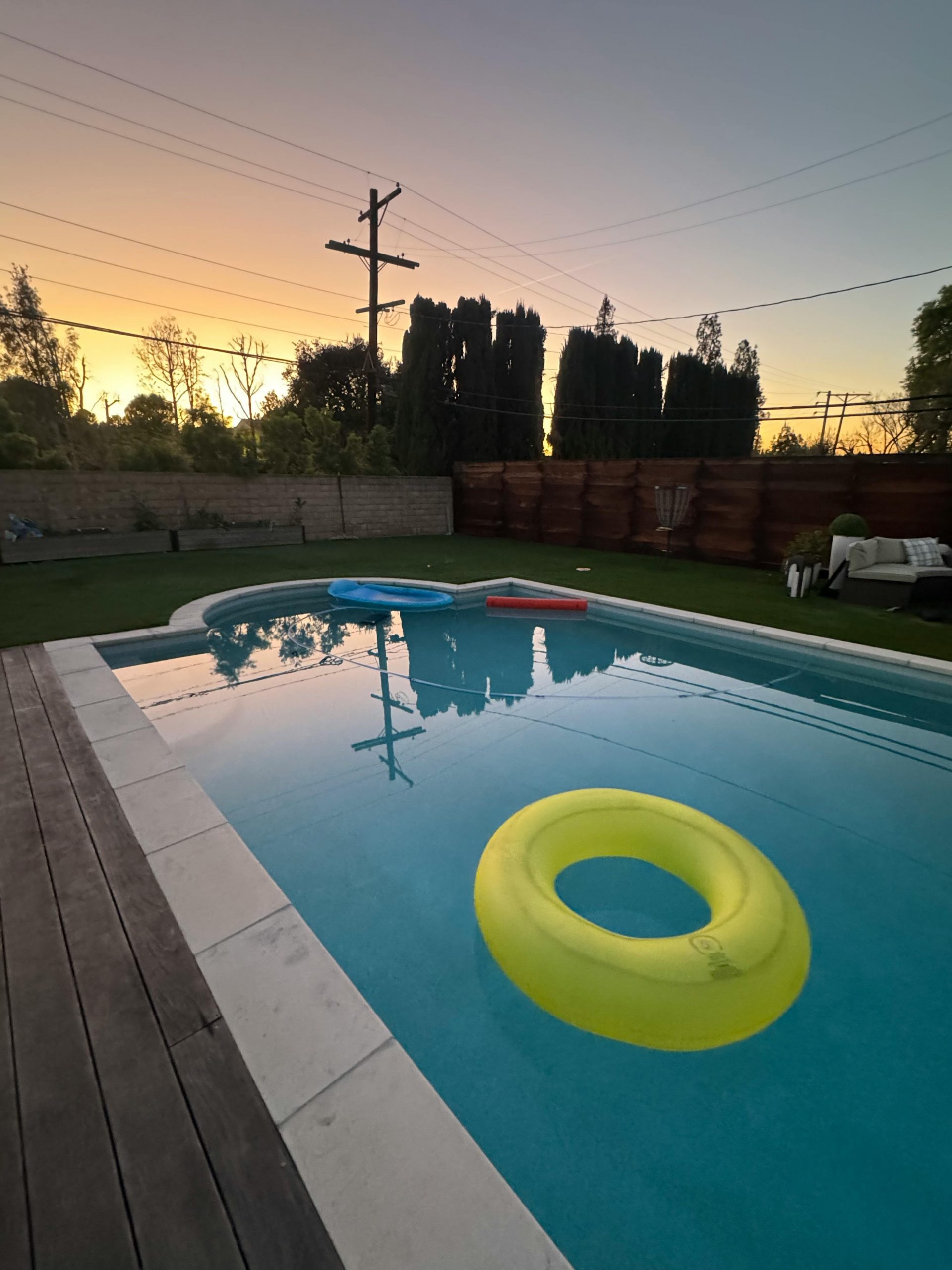 Backyard swimming pool with floaties at sunset, serene and inviting setting in Calabasas, CA.