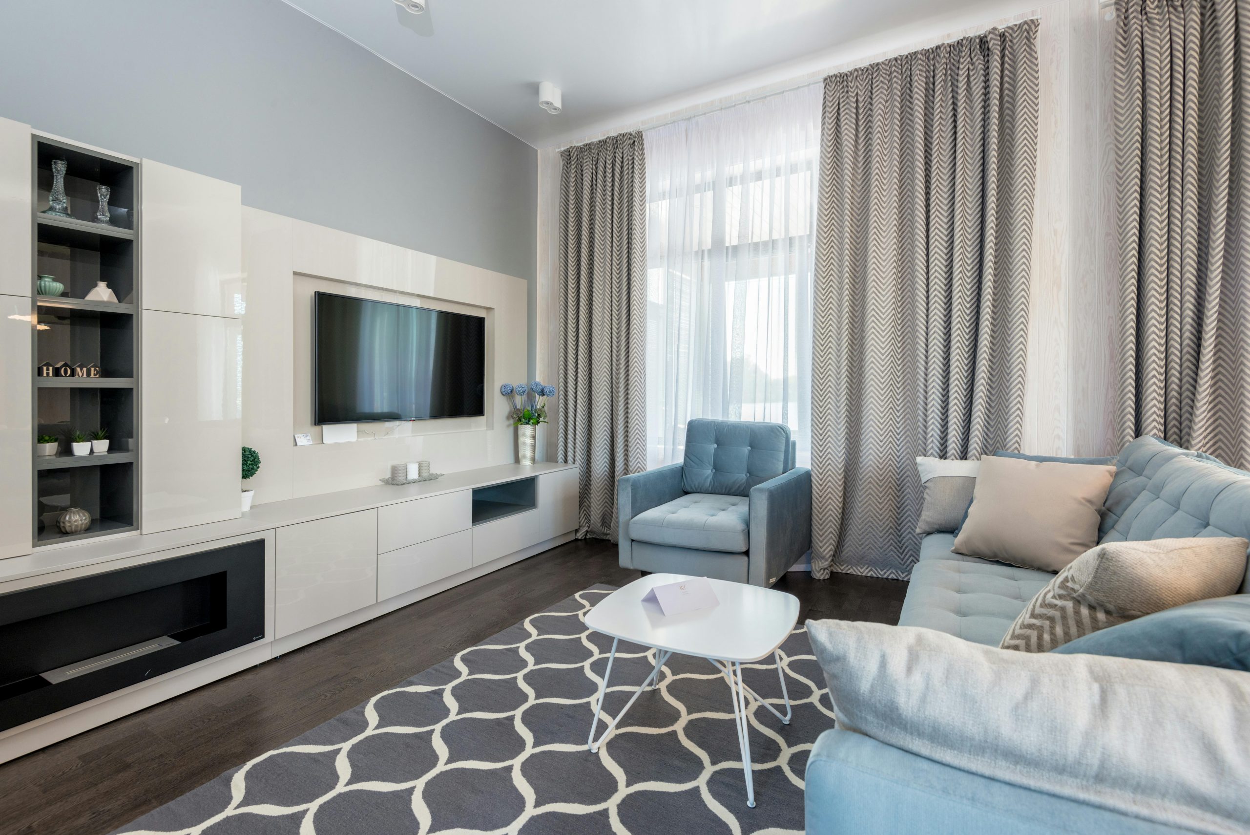 Bright and cozy modern living room featuring minimalist design and blue accents.