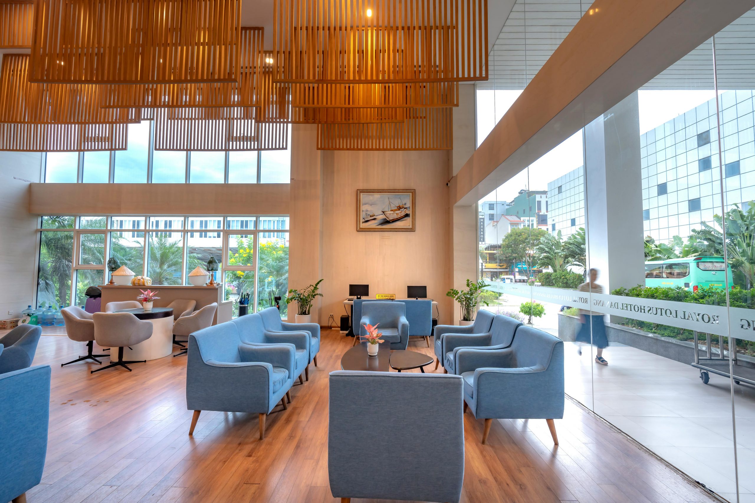 Bright hotel lobby with modern design, blue sofas, and wooden elements.