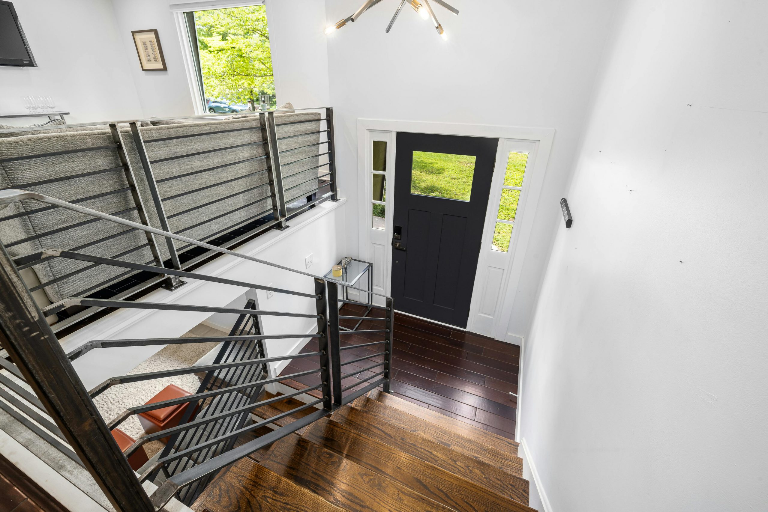 Bright, modern staircase entrance with minimalist design and wooden floors.