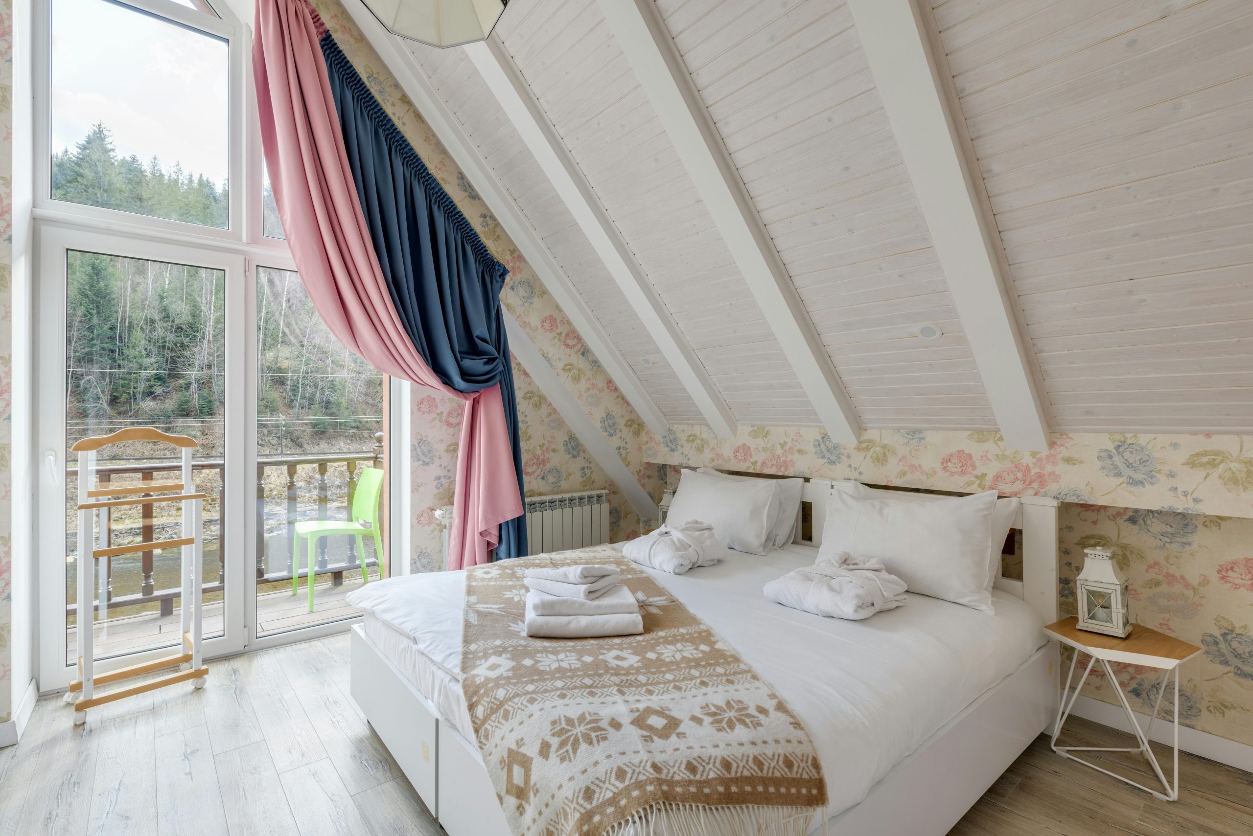 Charming rustic bedroom with attic ceiling and mountain view, perfect for relaxation.