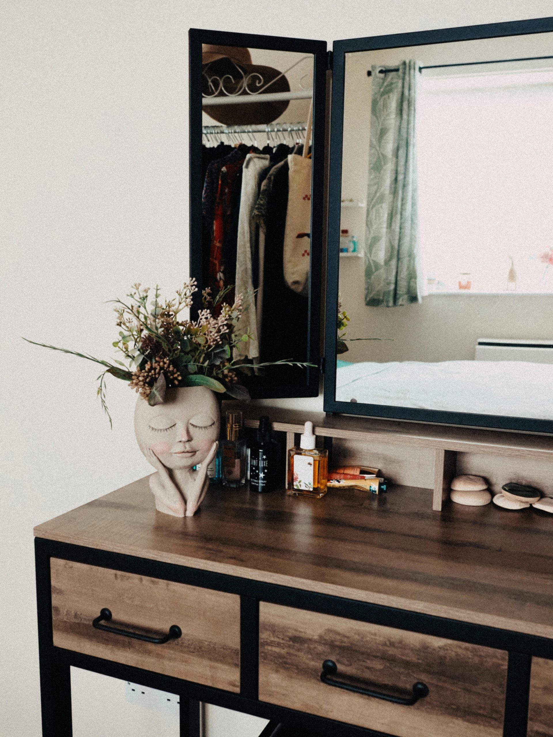 Chic bedroom vanity with wooden details and decorative mirror reflection.