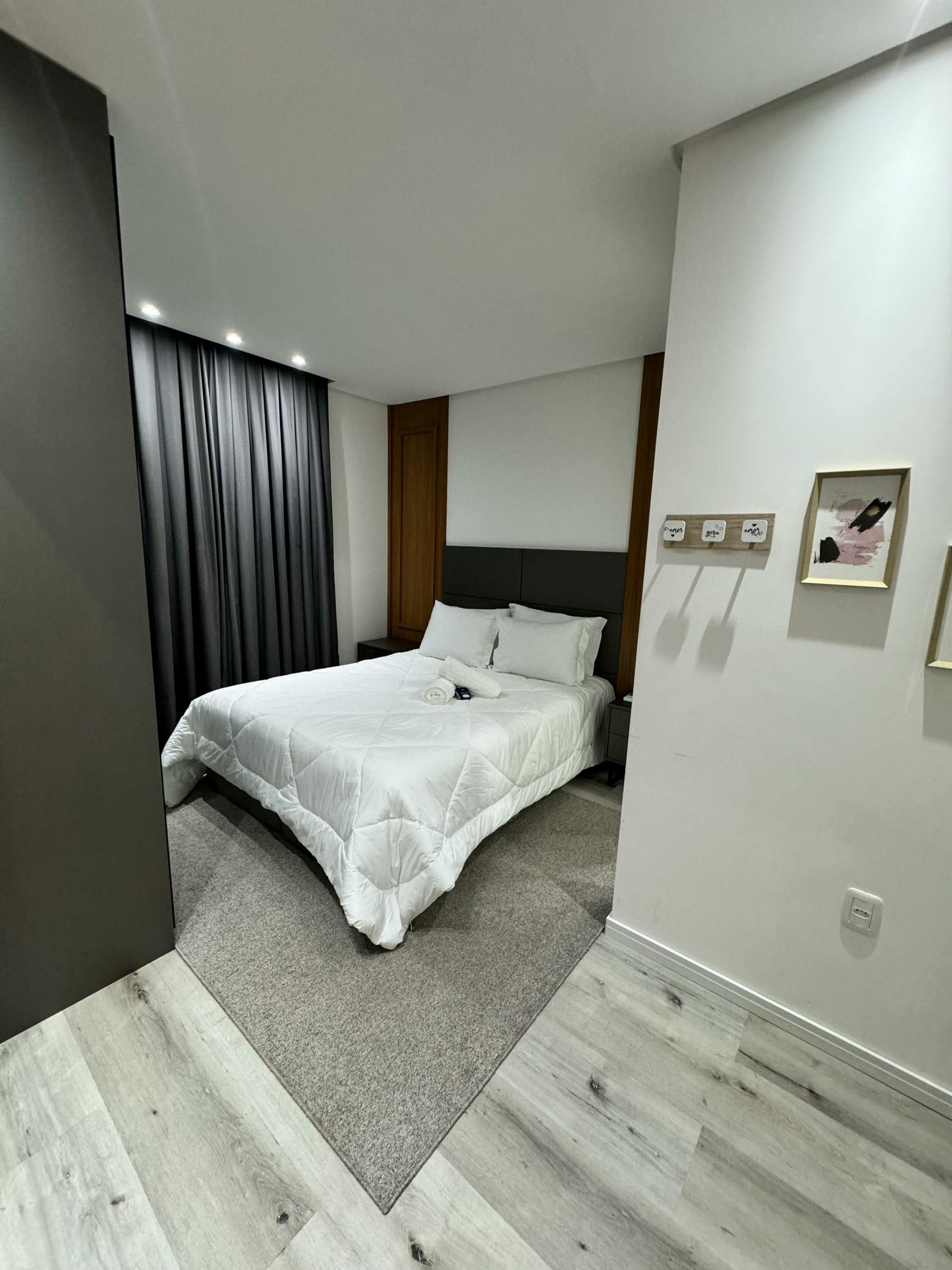 Chic modern bedroom interior featuring cozy bedding, wooden accents, and soft lighting.