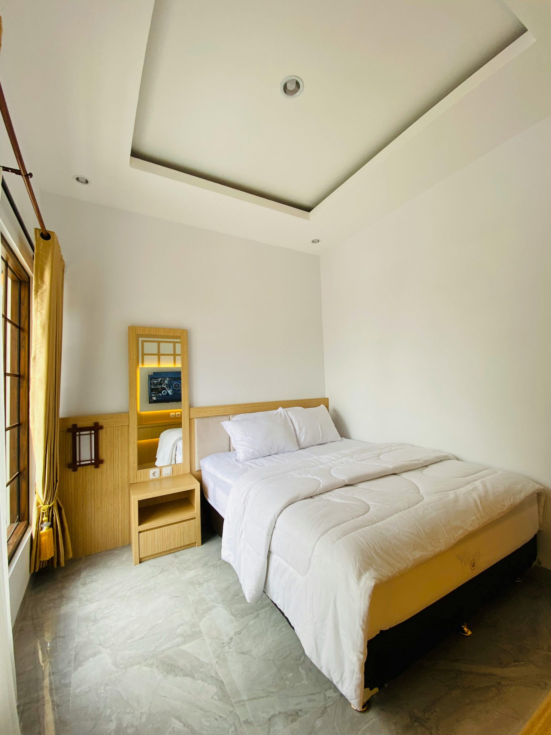 Clean and modern bedroom with white walls and cozy bedding.