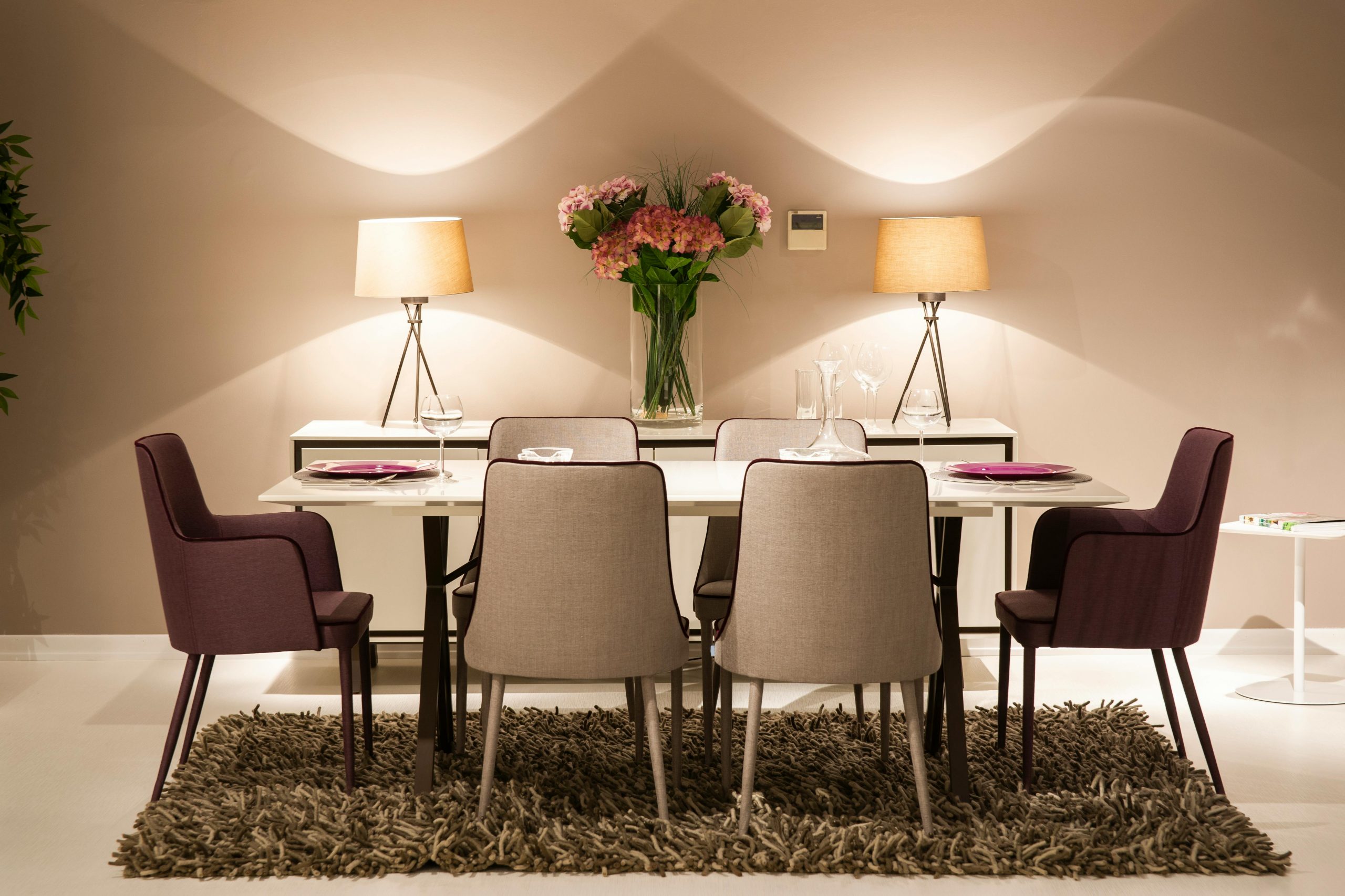 Contemporary dining area featuring modern chairs, table, and decorative lighting.
