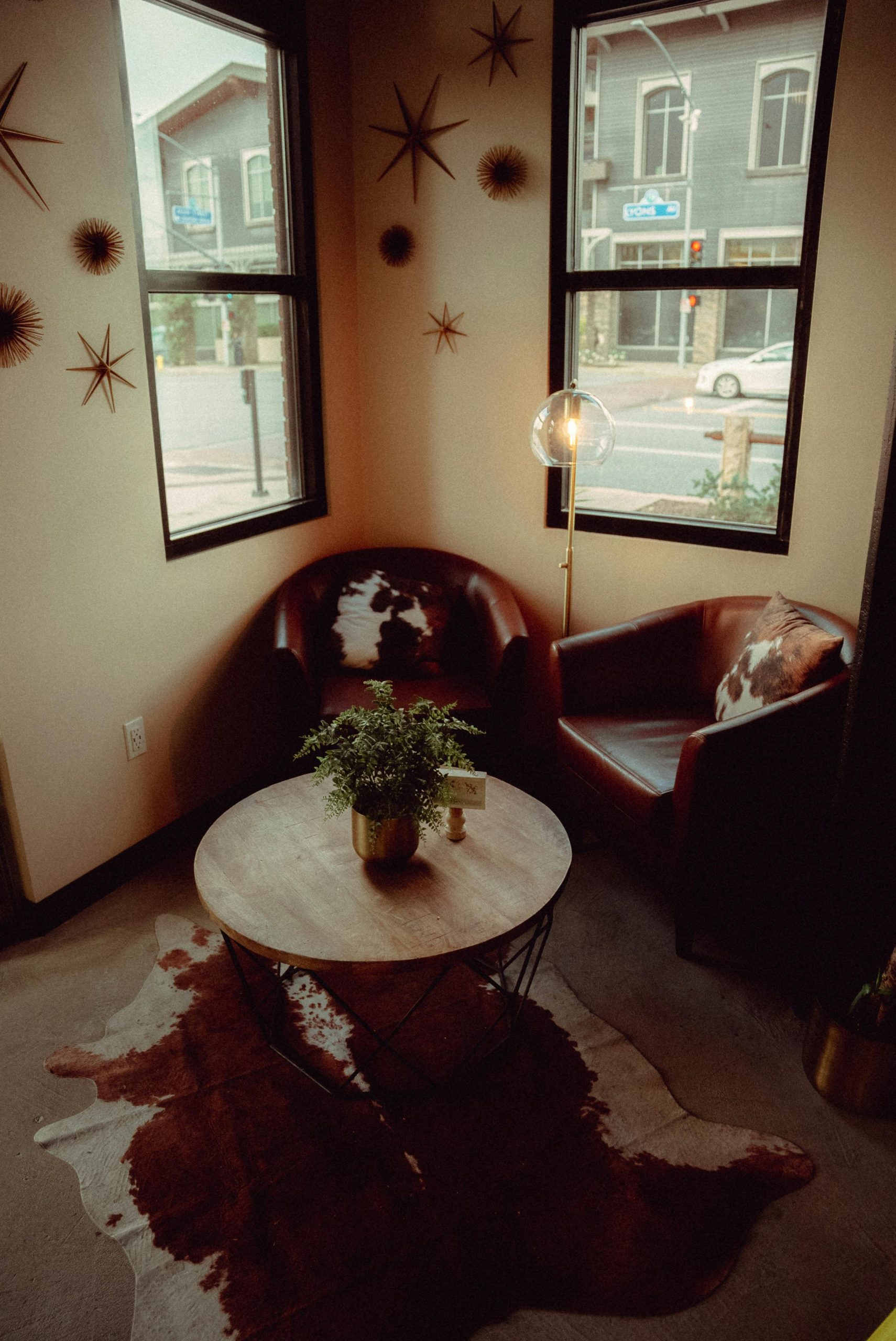 Cozy corner with armchairs, table, and window view in stylish urban setting.