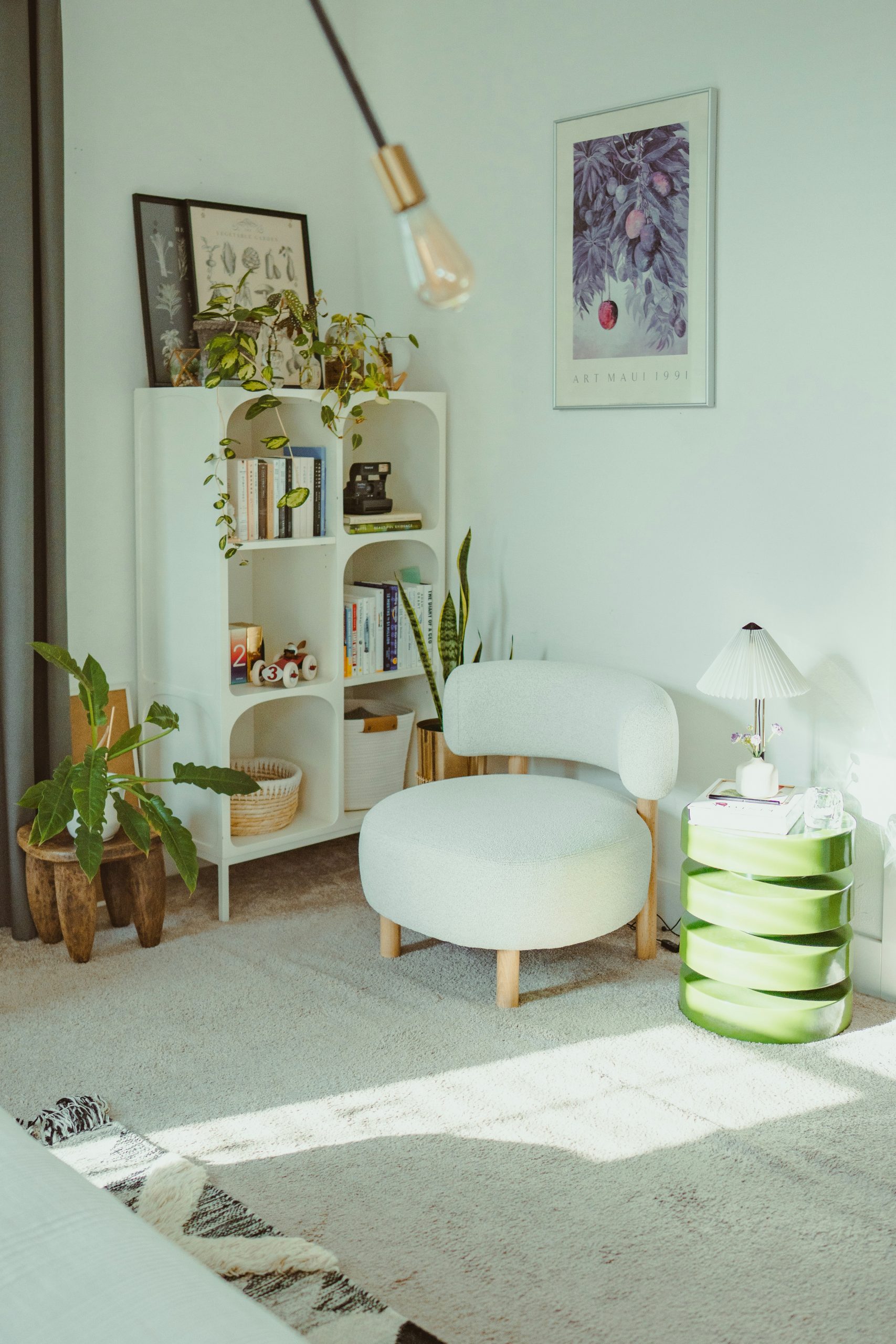 Cozy reading nook with plants and armchair.