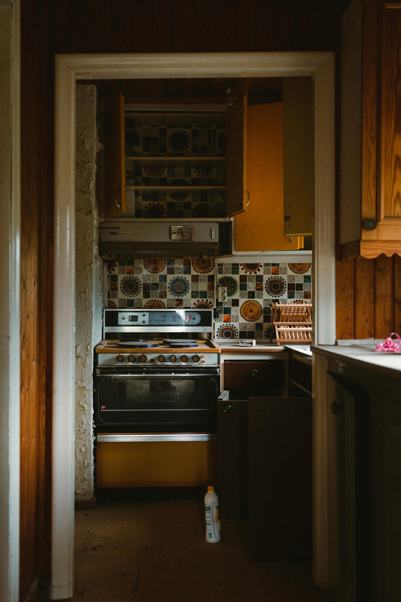 Cozy retro kitchen featuring vintage tiles, stove, and bold yellow cabinetry.