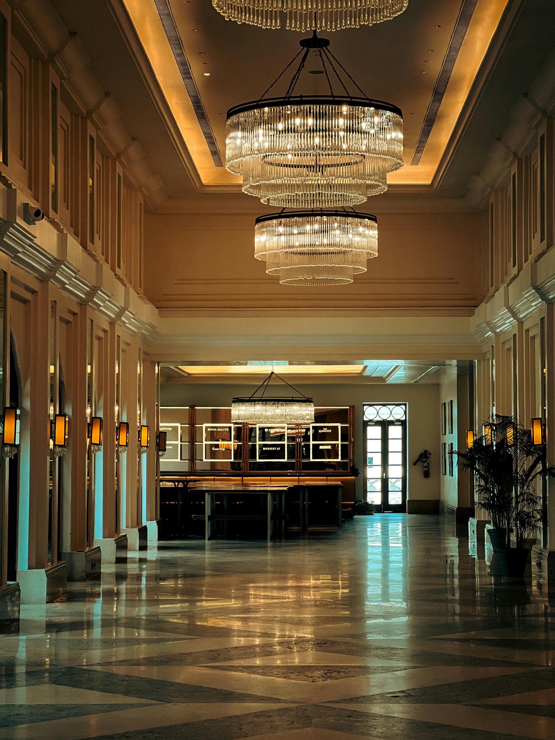 Elegant hotel lobby featuring large chandeliers and ambient lighting.