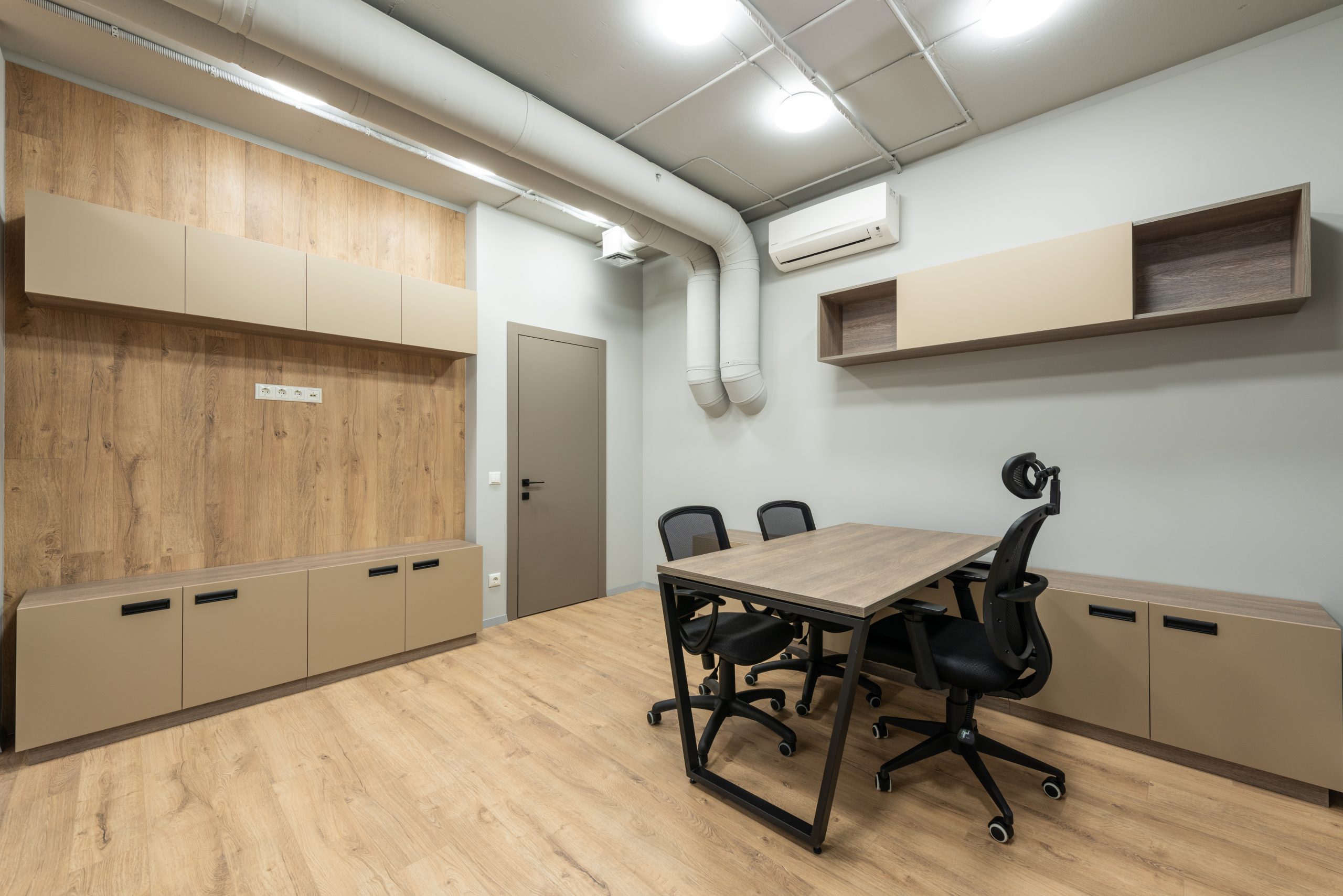 Interior of new workplace with wooden table and cabinets and black office chairs