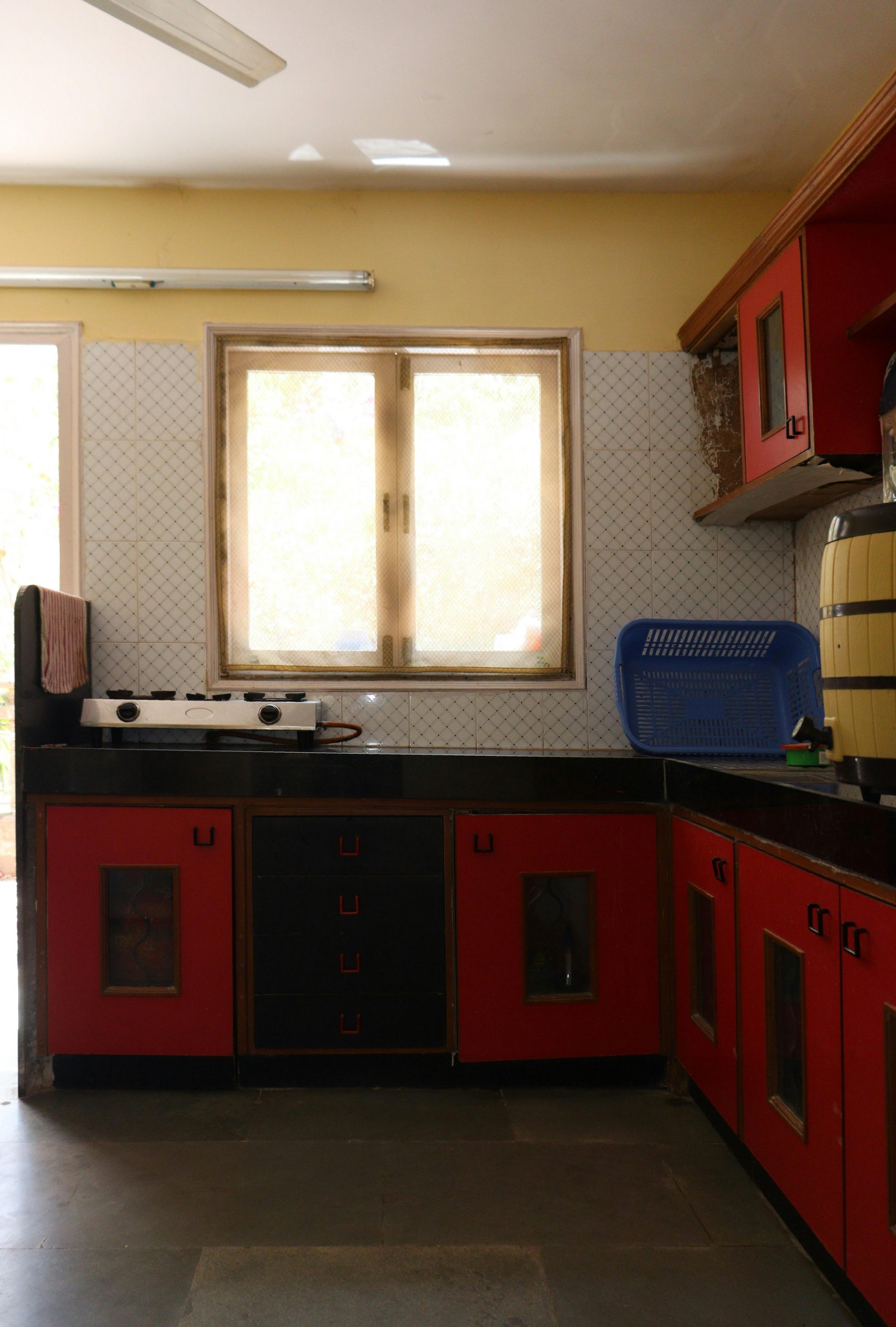 Interior view of a modern red and black kitchen with natural lighting.