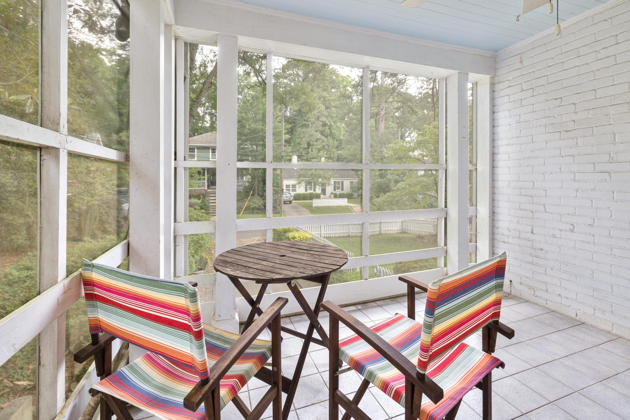 Inviting patio view with colorful chairs and table, perfect for relaxation.