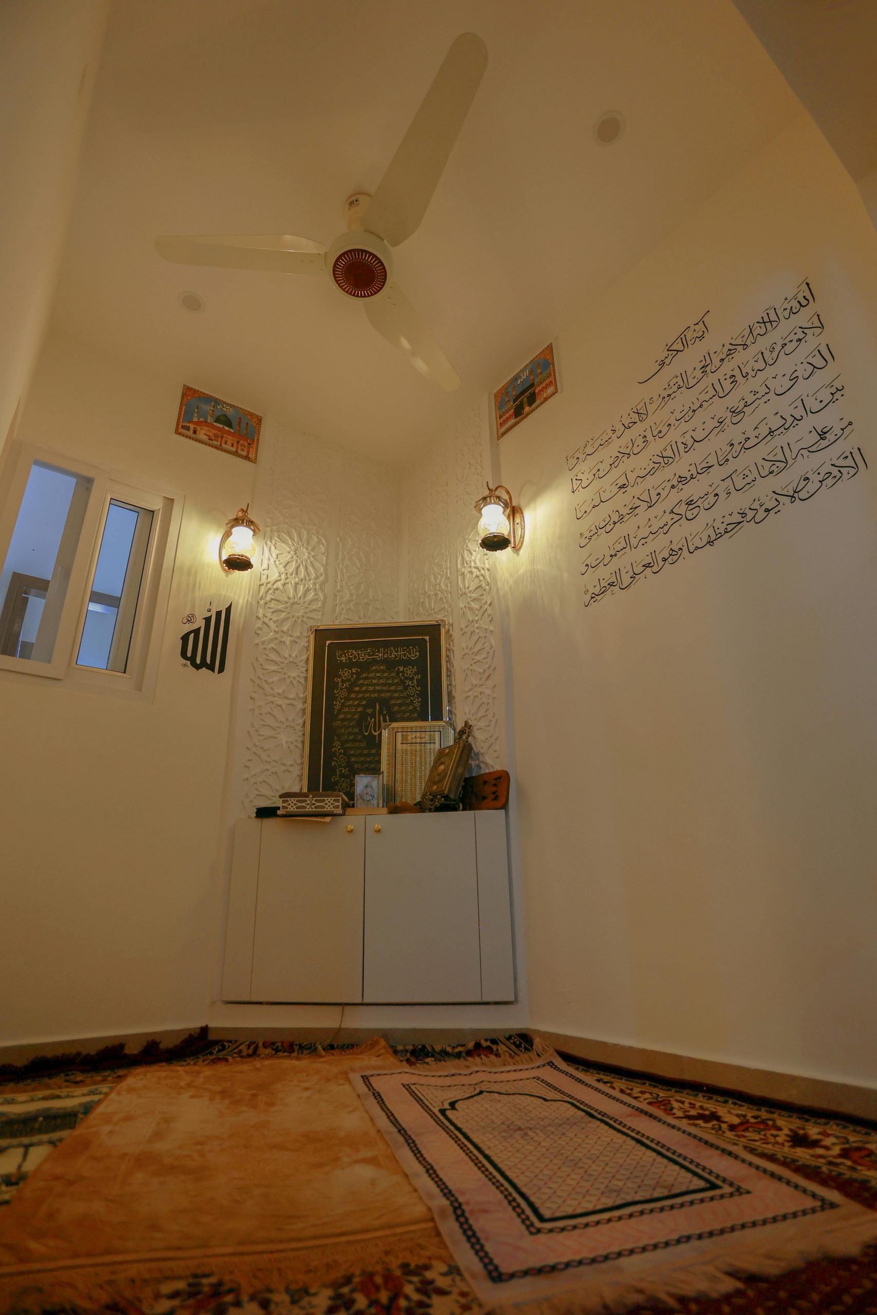 Inviting prayer space featuring traditional decor and Arabic text on a white wall.