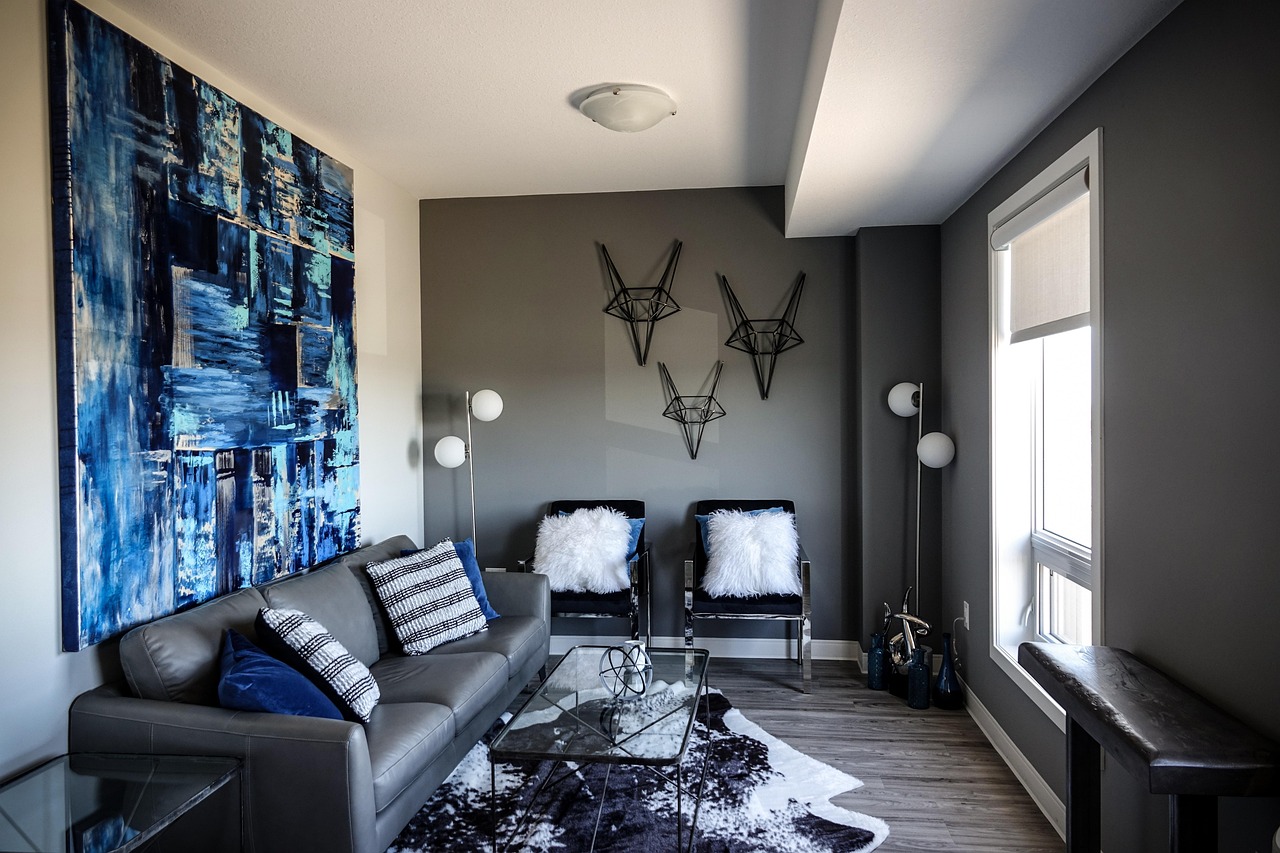 living room, blue, blue painting, painting, wall decor, abstract art, abstract wall hangings, grey couch, grey, modern, neutral, side table, light blue, fuzzy pillow, white pillow, lamp, luxury, luxur