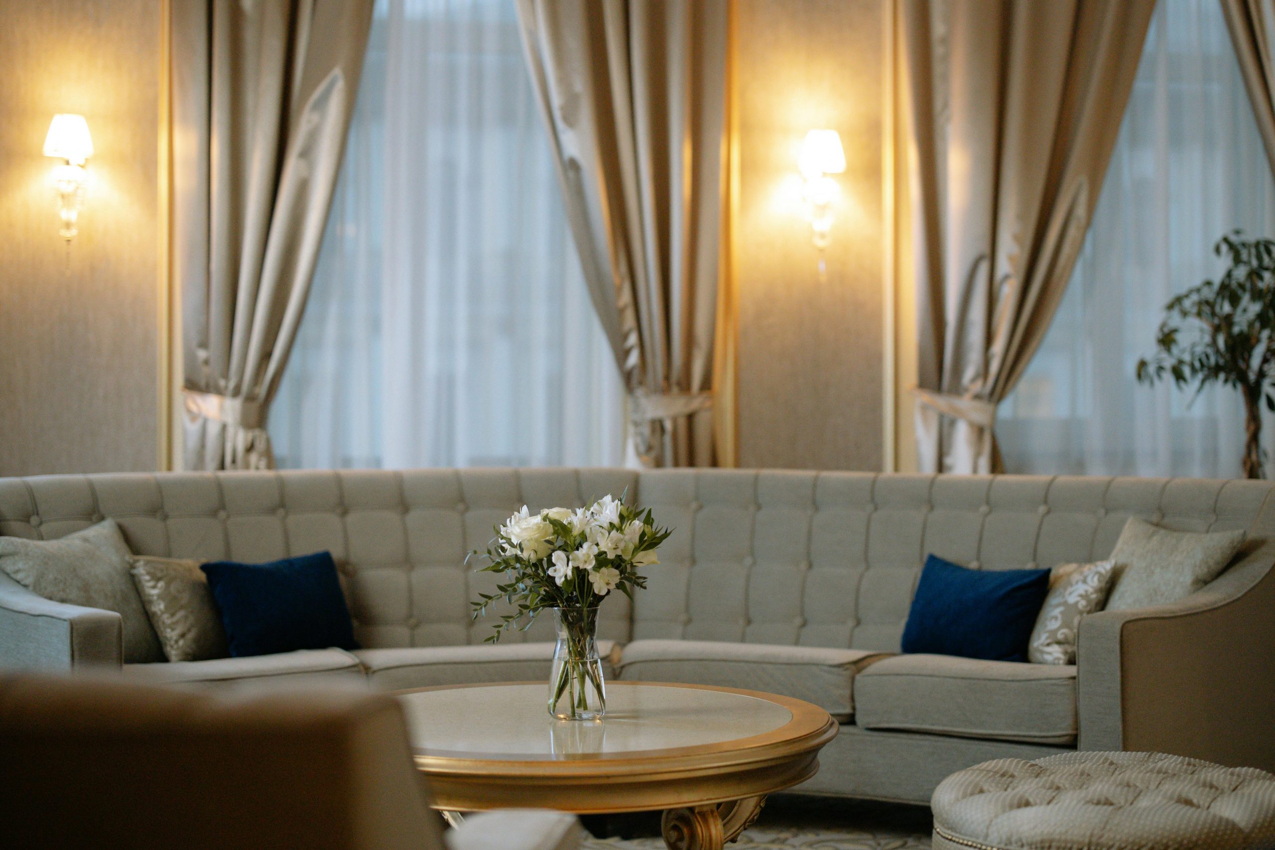 Luxurious lounge area featuring a plush sofa, chic curtains, and soft lighting.