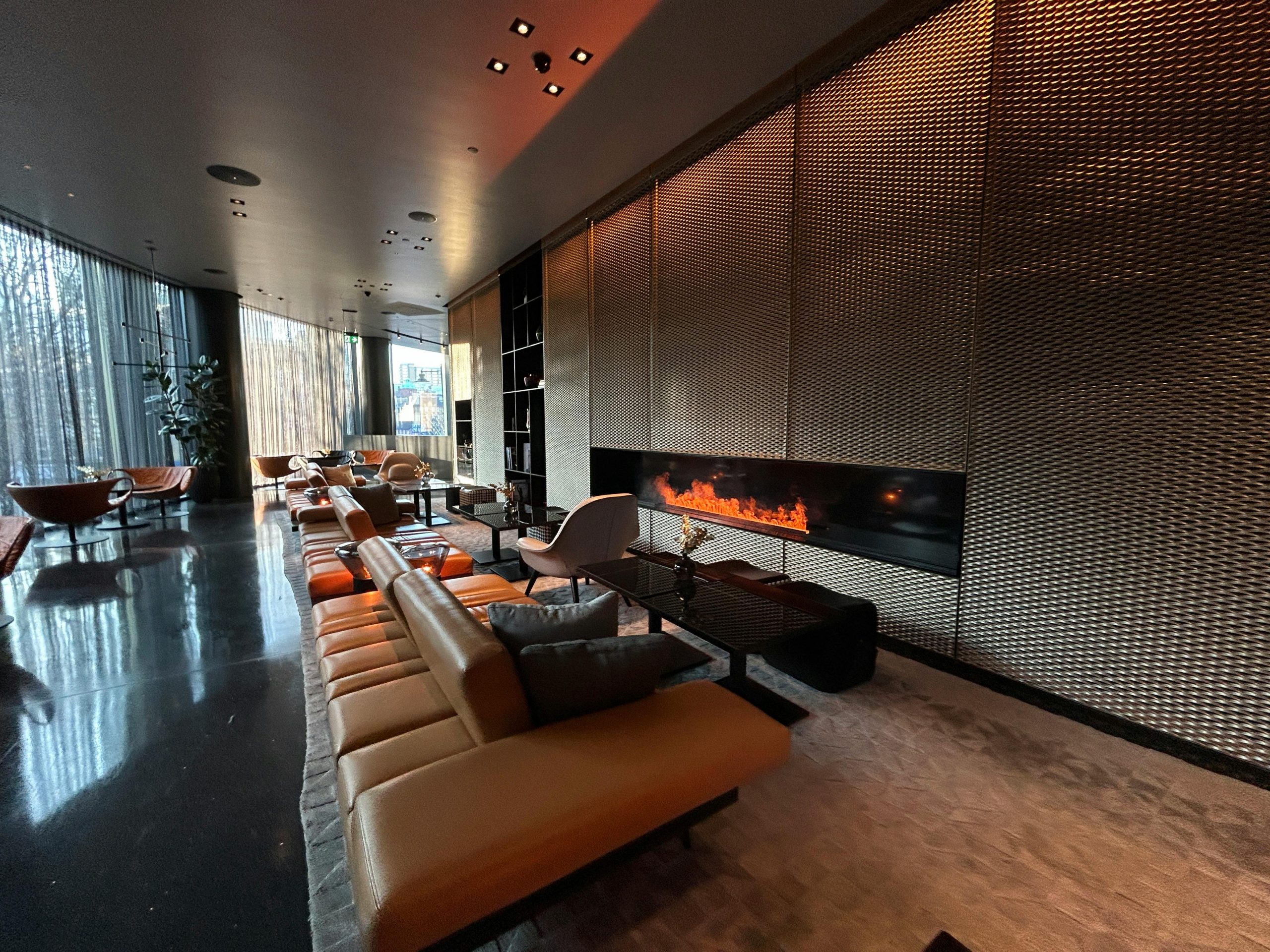 Luxurious modern hotel lounge featuring a sleek design and warm fireplace.
