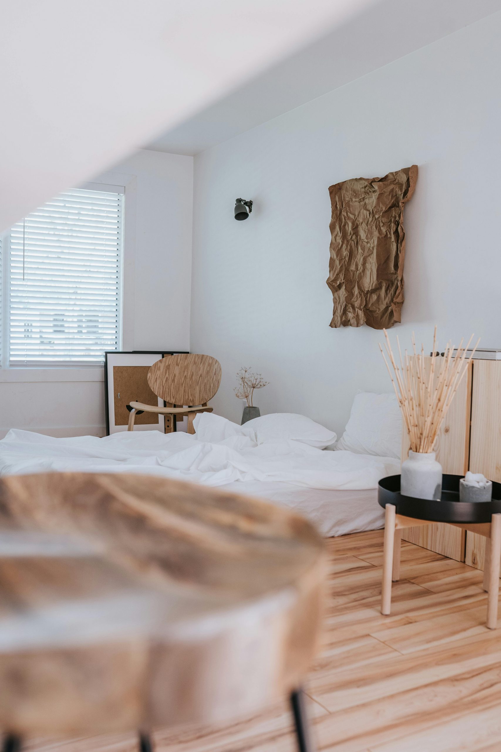 Serene minimalist bedroom with wooden accents and white bedding.