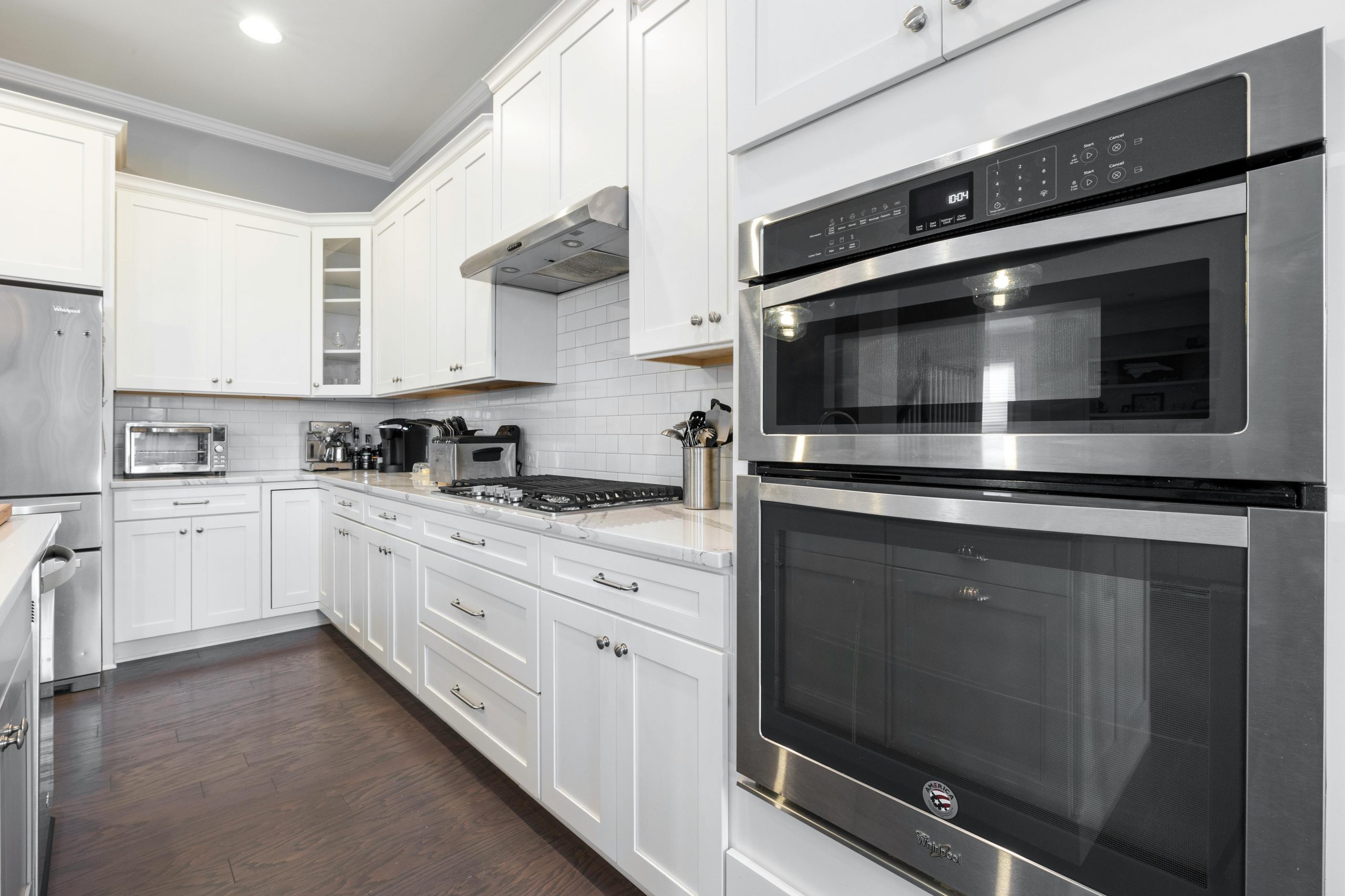 Sleek and modern white kitchen featuring stainless steel appliances and elegant cabinetry.
