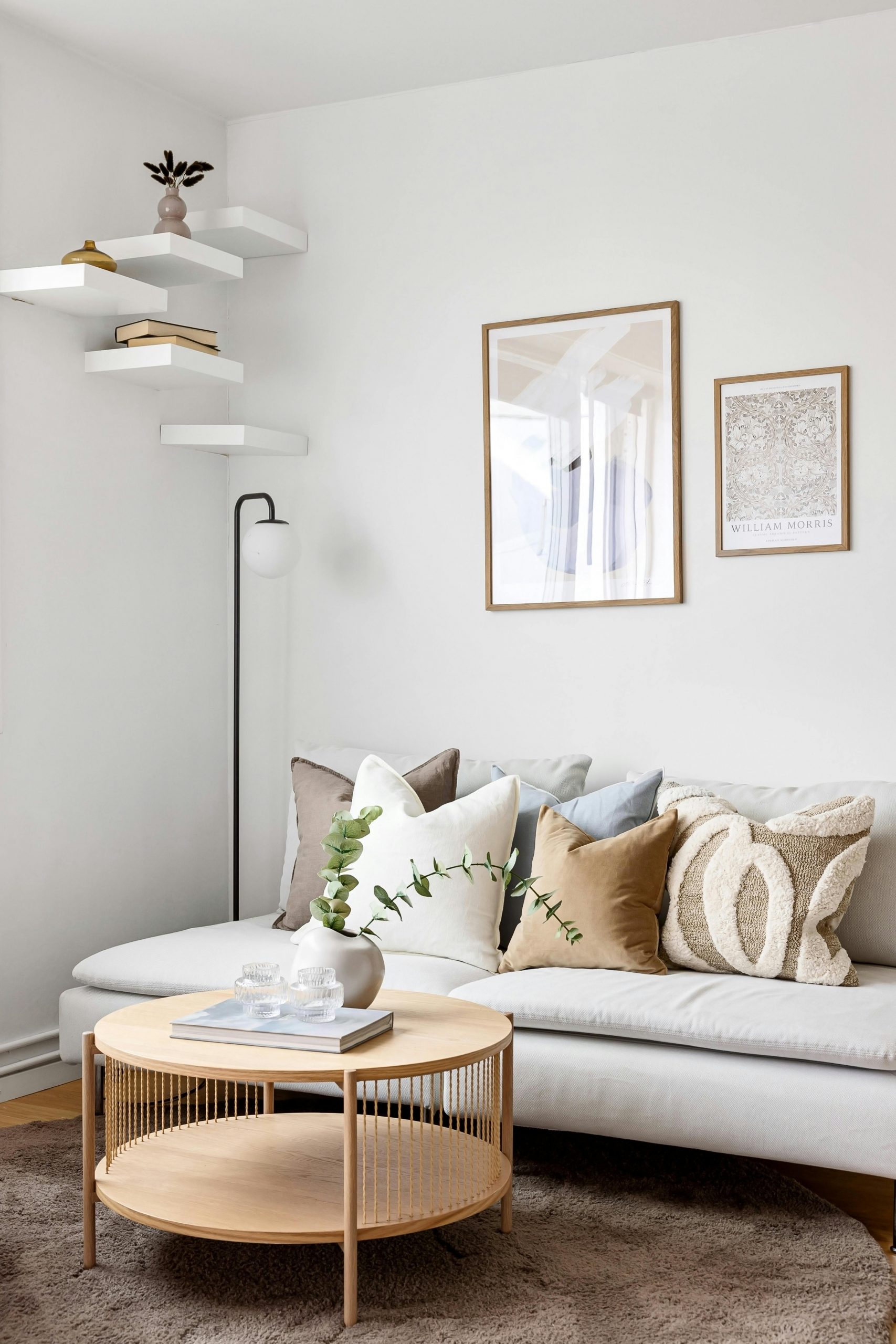 Sleek and stylish minimalist living room featuring a plush sofa, cushions, and decorative elements.
