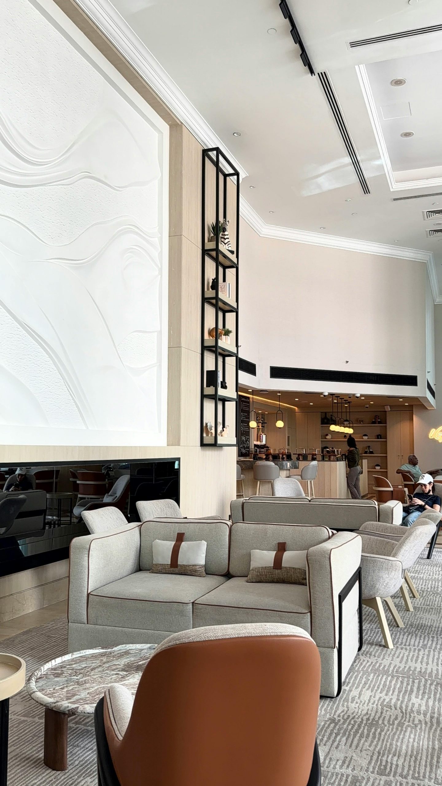Spacious hotel lobby with contemporary decor and comfortable seating in natural lighting.