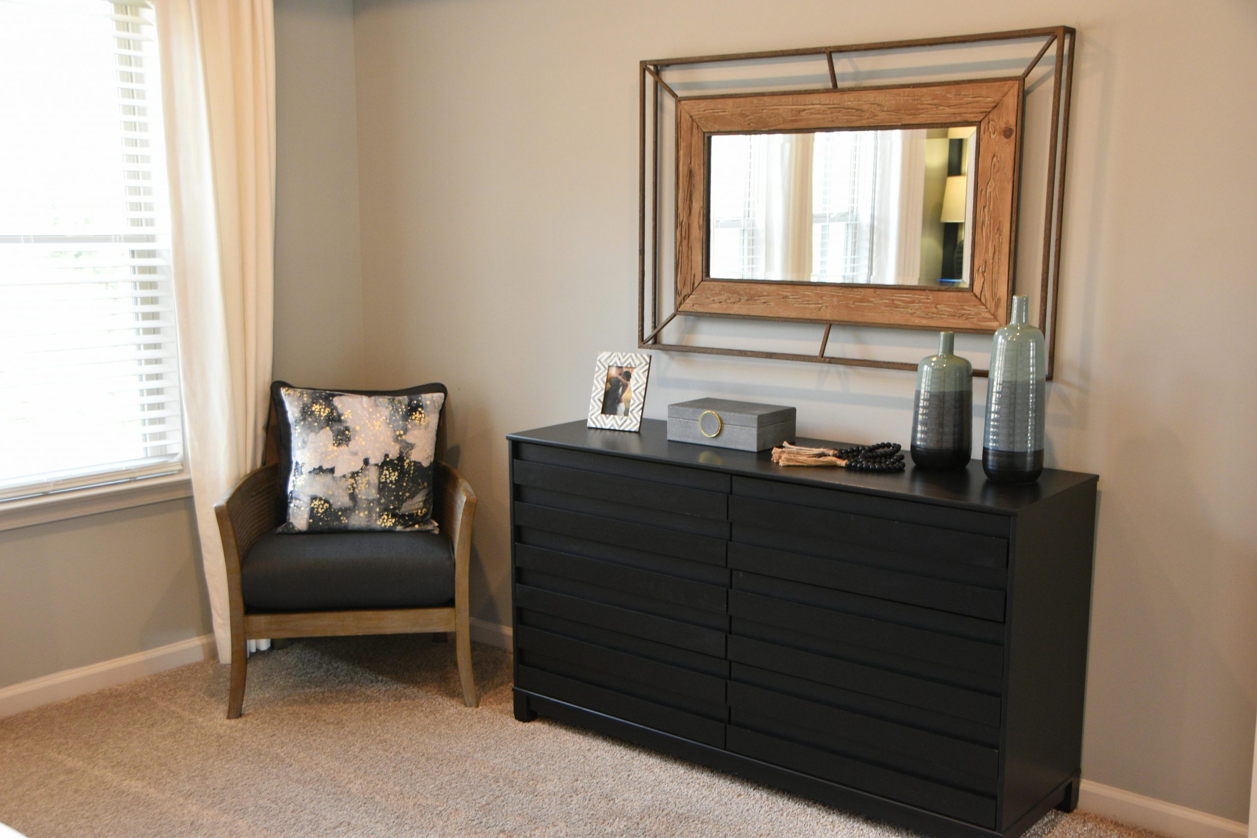 Stylish bedroom interior featuring a modern dresser, chair, and decorative elements creating a cozy atmosphere.